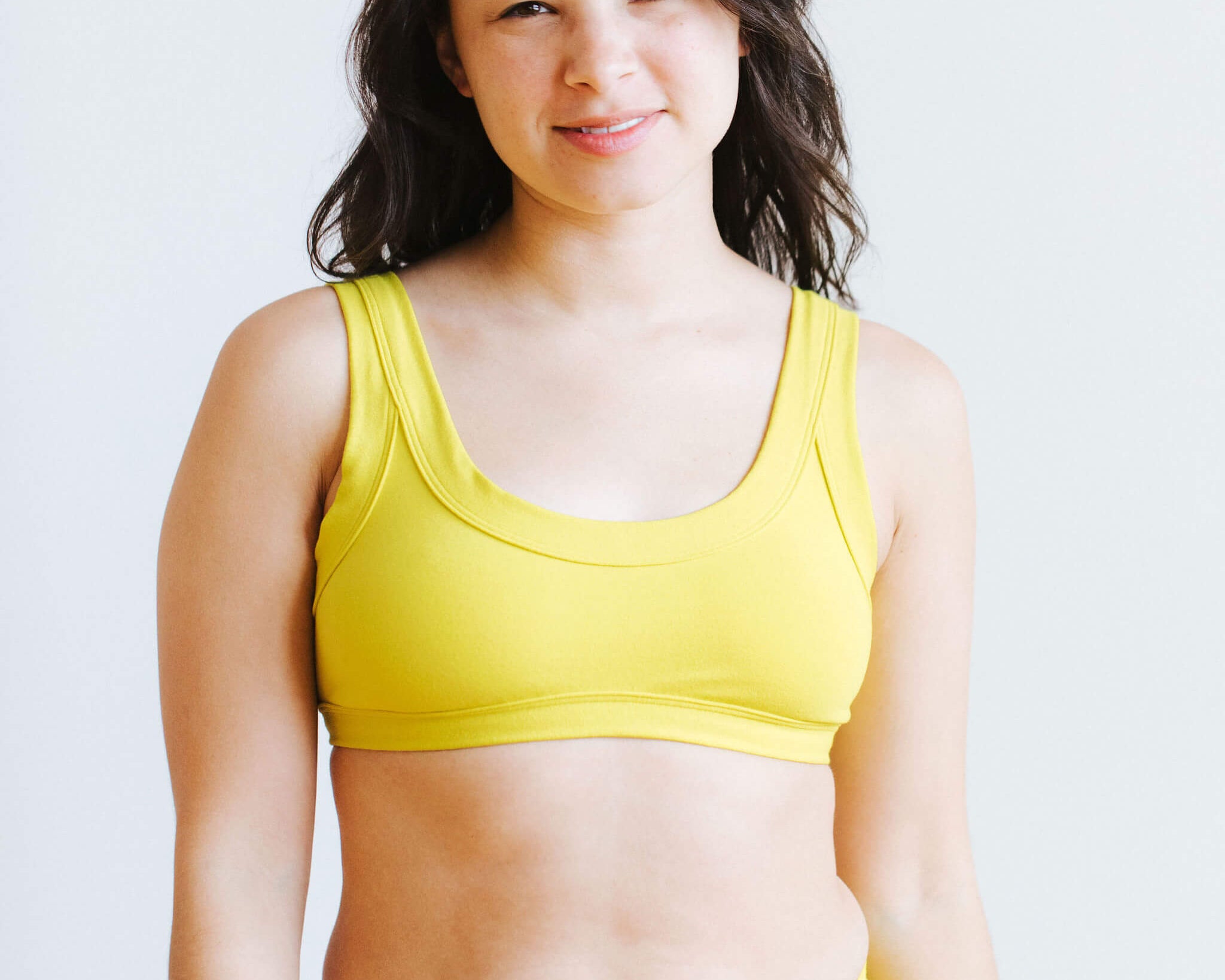 Model wearing Thunderpants Bralette in Star Fruit color - a chartreuse yellow.