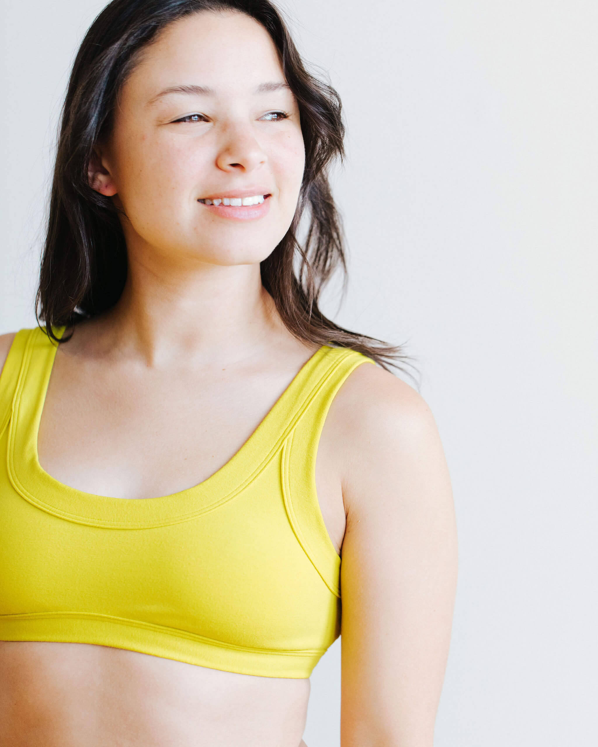 Model wearing Thunderpants Bralette in Star Fruit color - a chartreuse yellow.