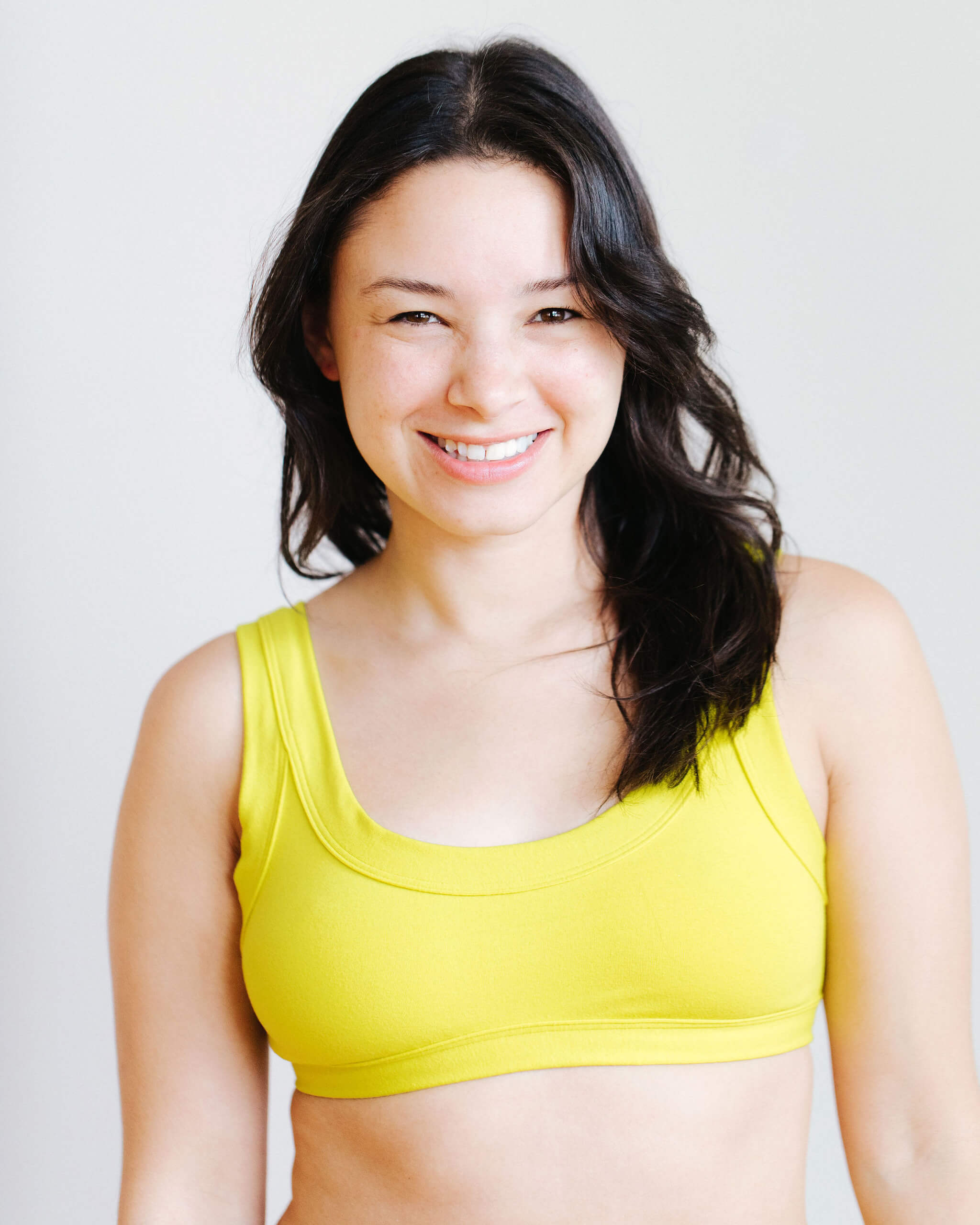 Model wearing Thunderpants Bralette in Star Fruit color - a chartreuse yellow.