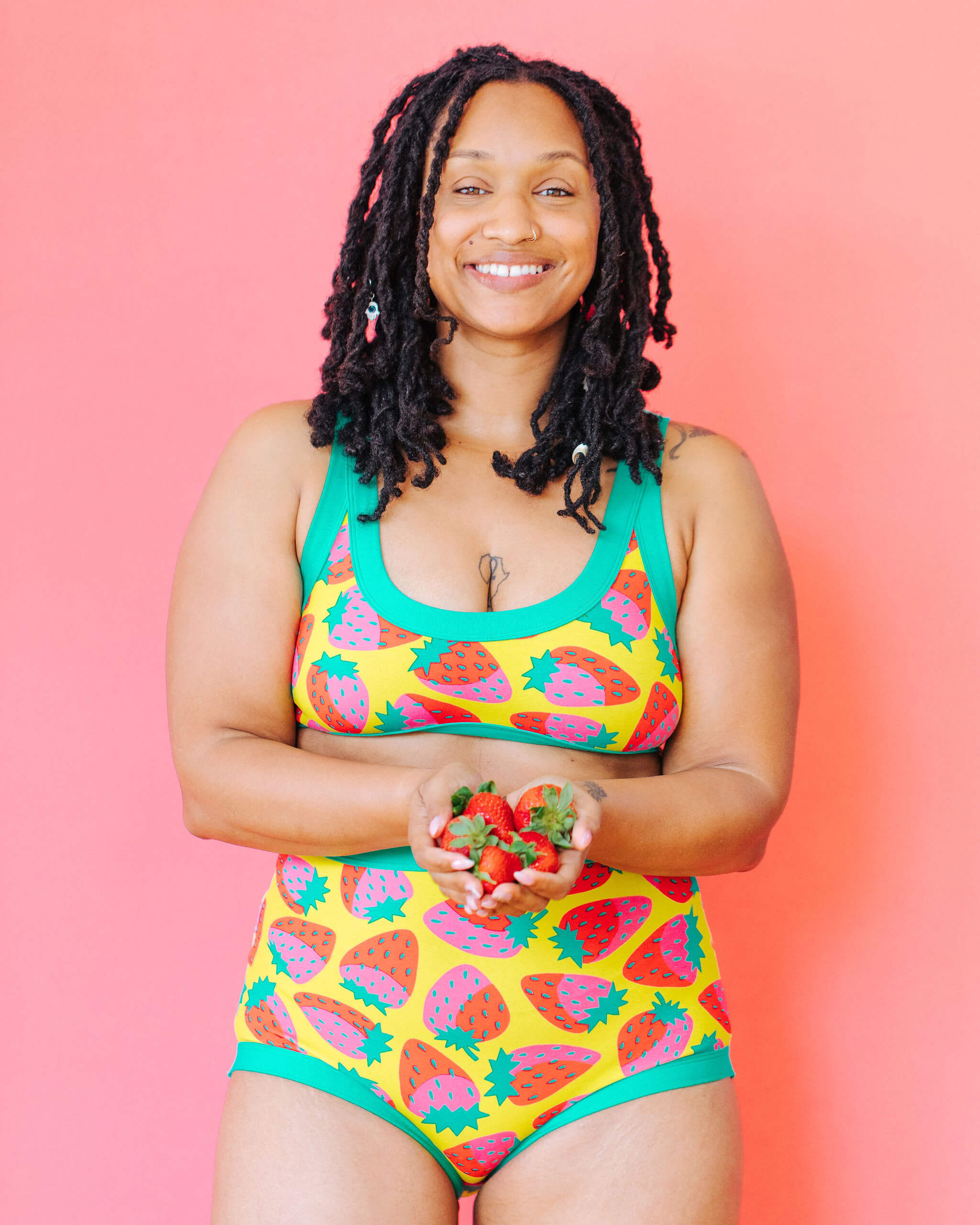 Model wearing Thunderpants Bralette and Sky Rise style underwear in a Strawberry print - pink, red, and peacock green on chartreuse. 