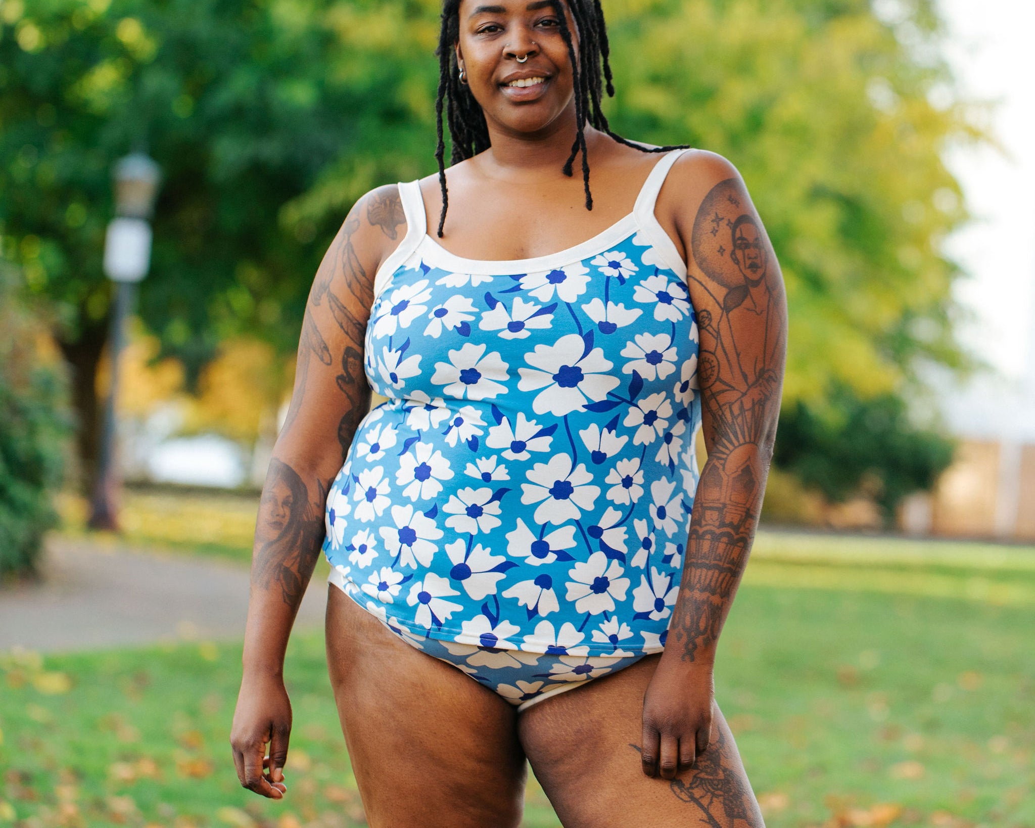 Model wearing Thunderpants Camisole  and Hipster style underwear in Moody Blooms - white and blue flowers with blue background.