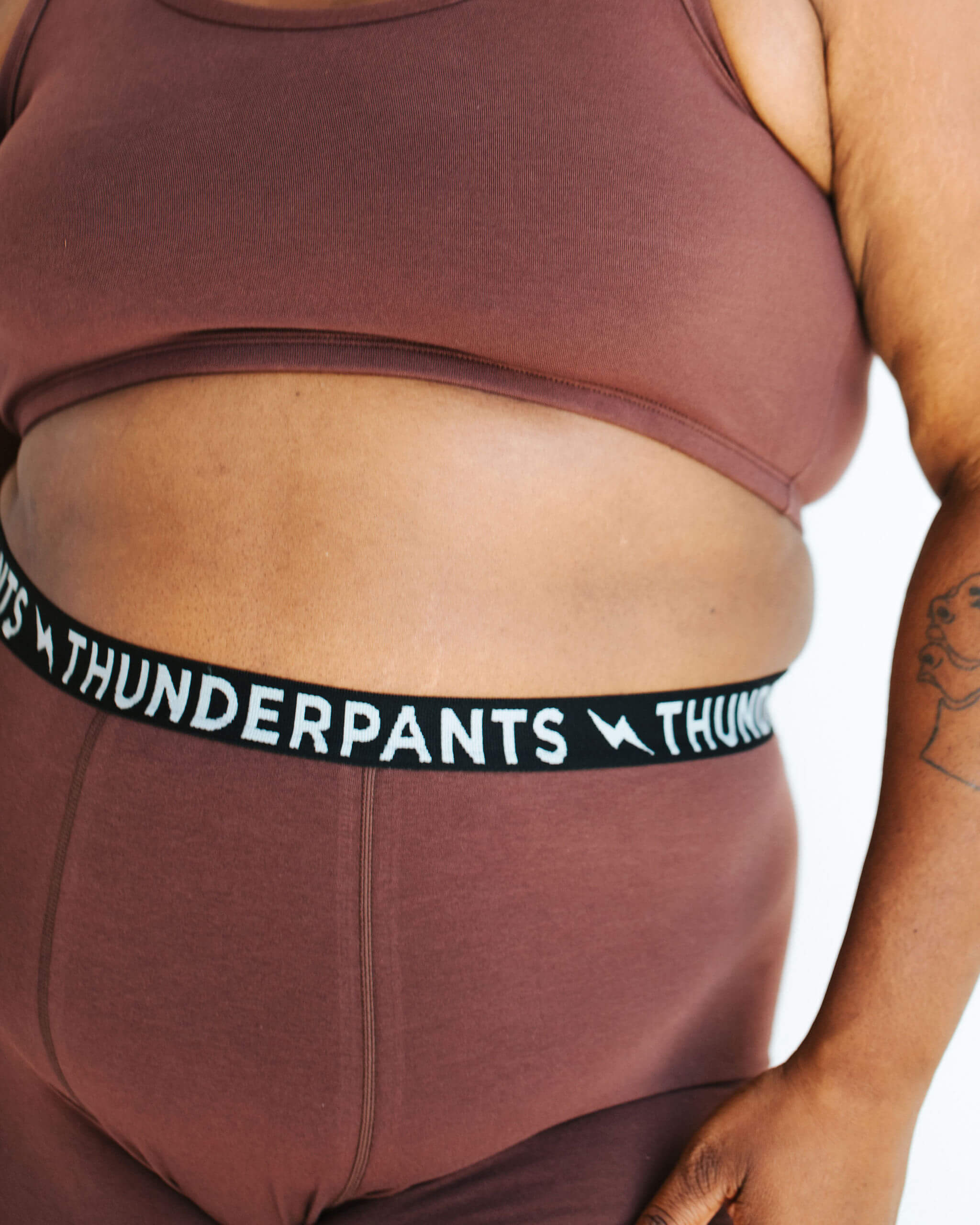 Close up of model wearing Thunderpants Boxer Brief style underwear and Longline Bra in Chestnut - dark brown color.