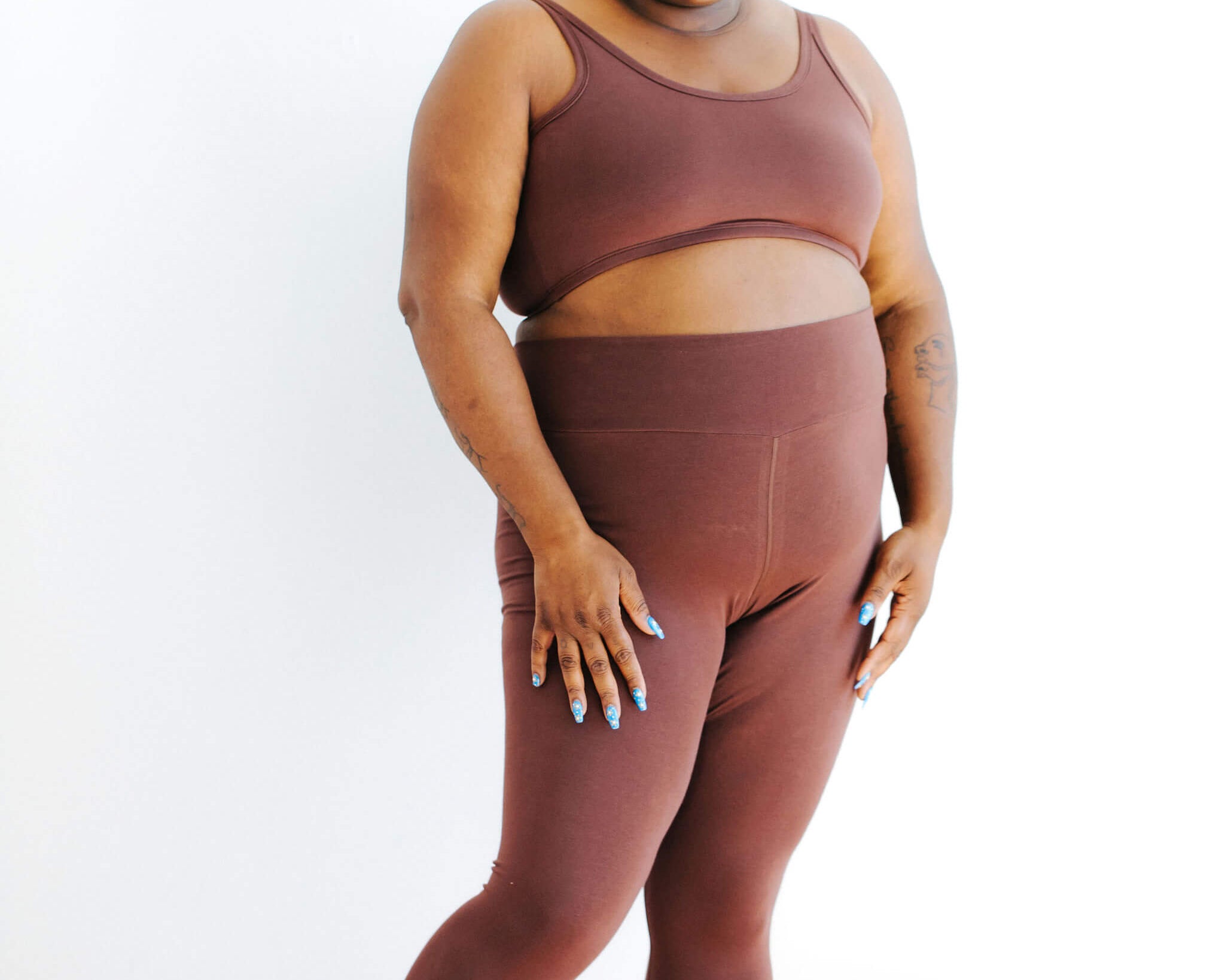 Model wearing Thunderpants Ankle Leggings and Longline Bra in Chestnut - a dark brown color.