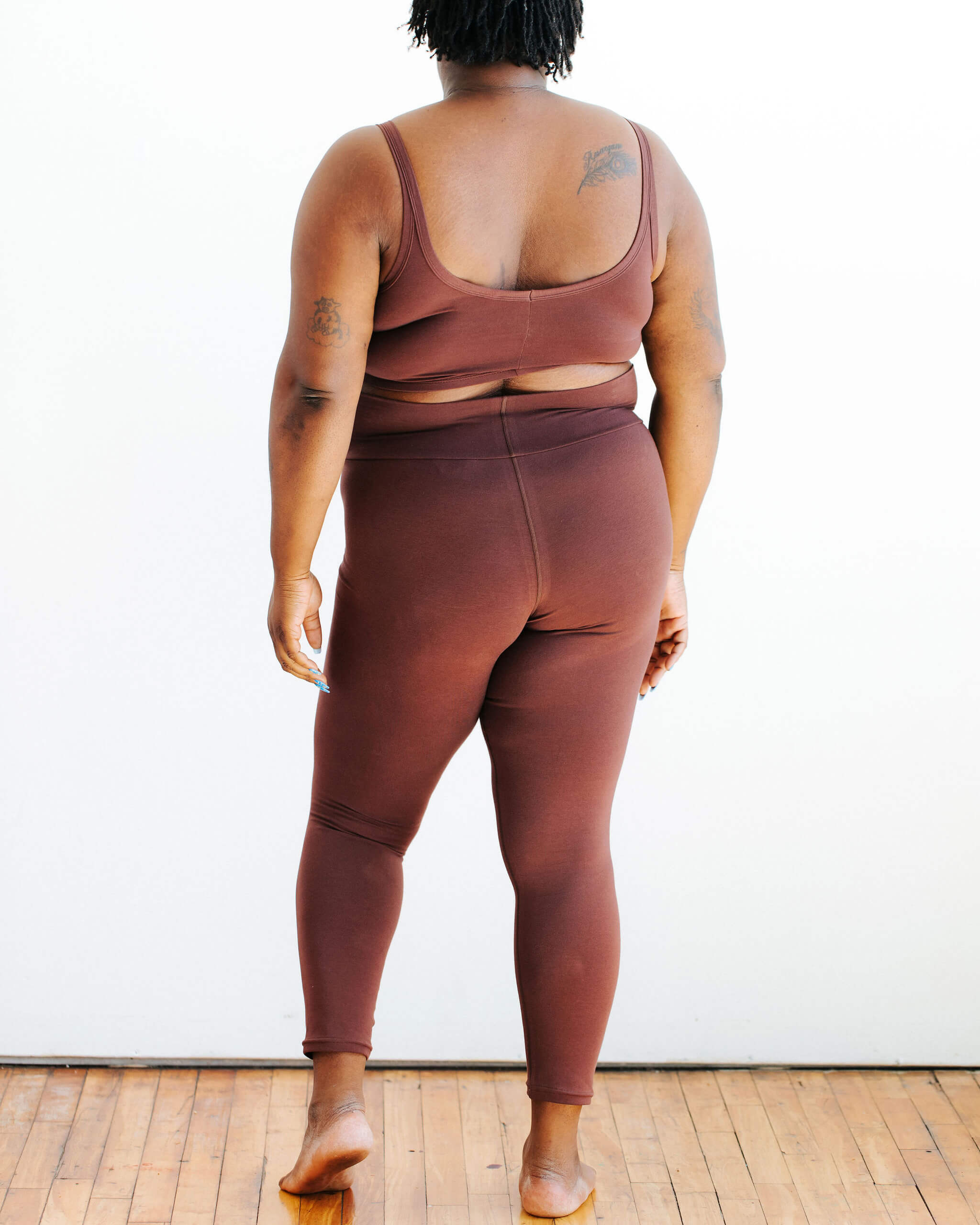 Model wearing Thunderpants Ankle Leggings and Longline Bra in Chestnut - a dark brown color.