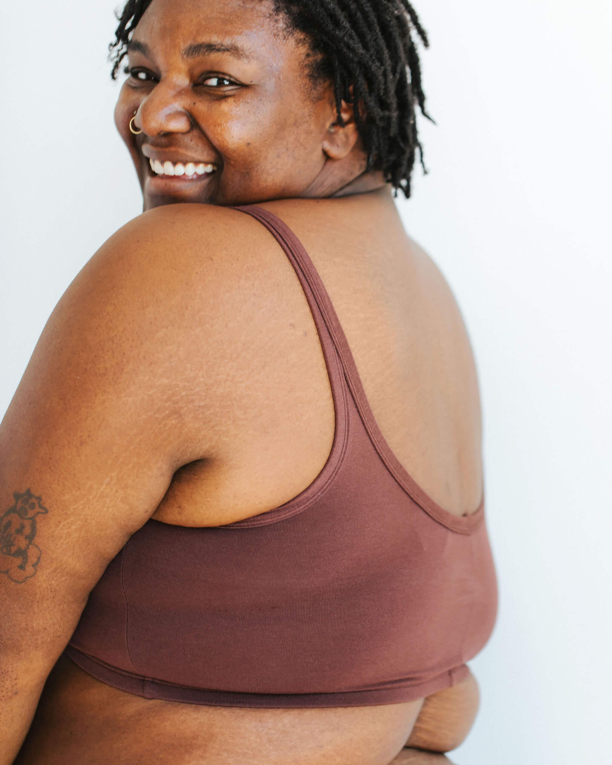 Close up of model wearing Thunderpants Longline Bra in Chestnut - a dark brown color.