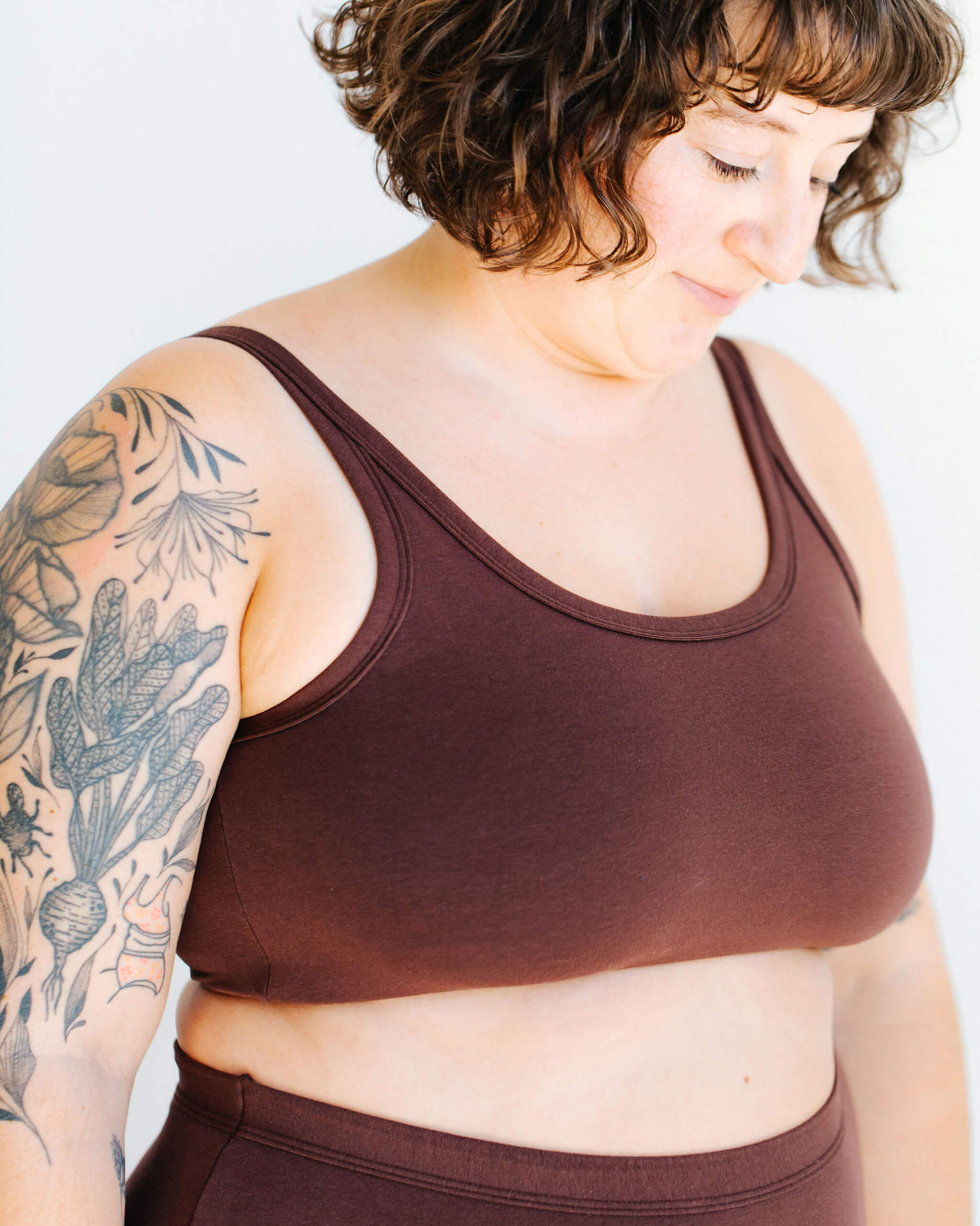 Close up of model wearing Thunderpants Longline Bra in Chestnut - a dark brown color.