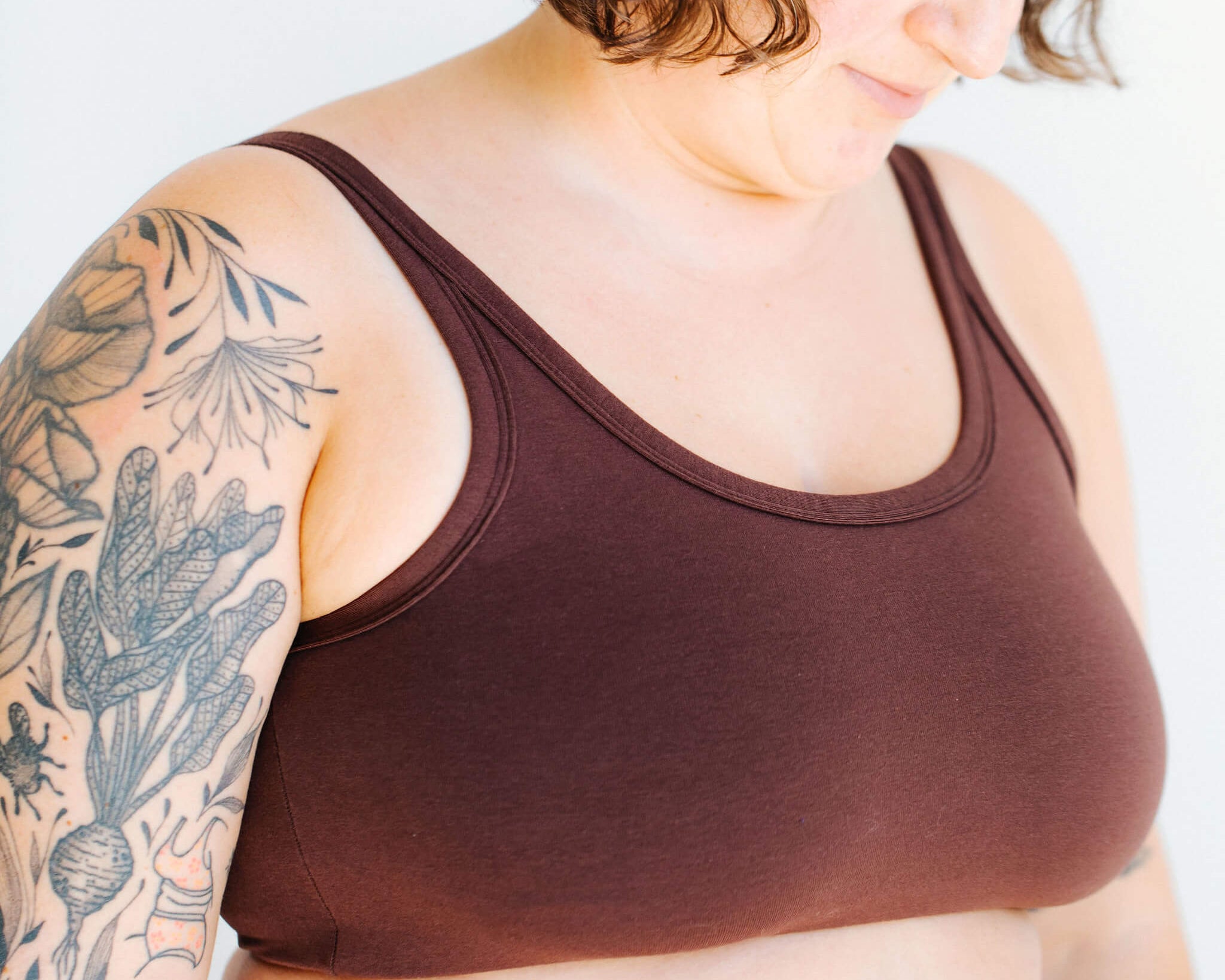 Close up of model wearing Thunderpants Longline Bra in Chestnut - a dark brown color.