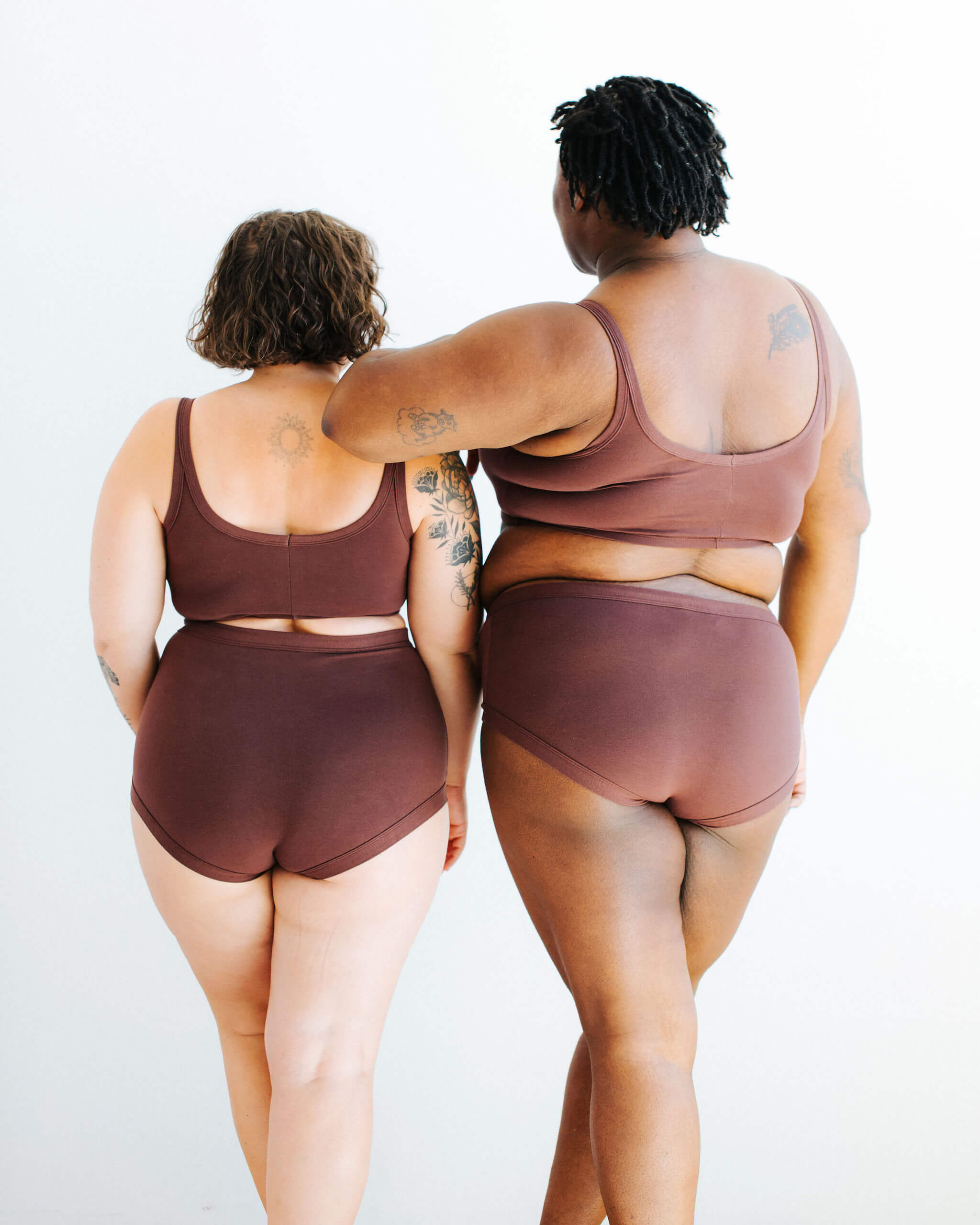 Two models wearing various Thunderpants styles in Chestnut - a dark brown color.