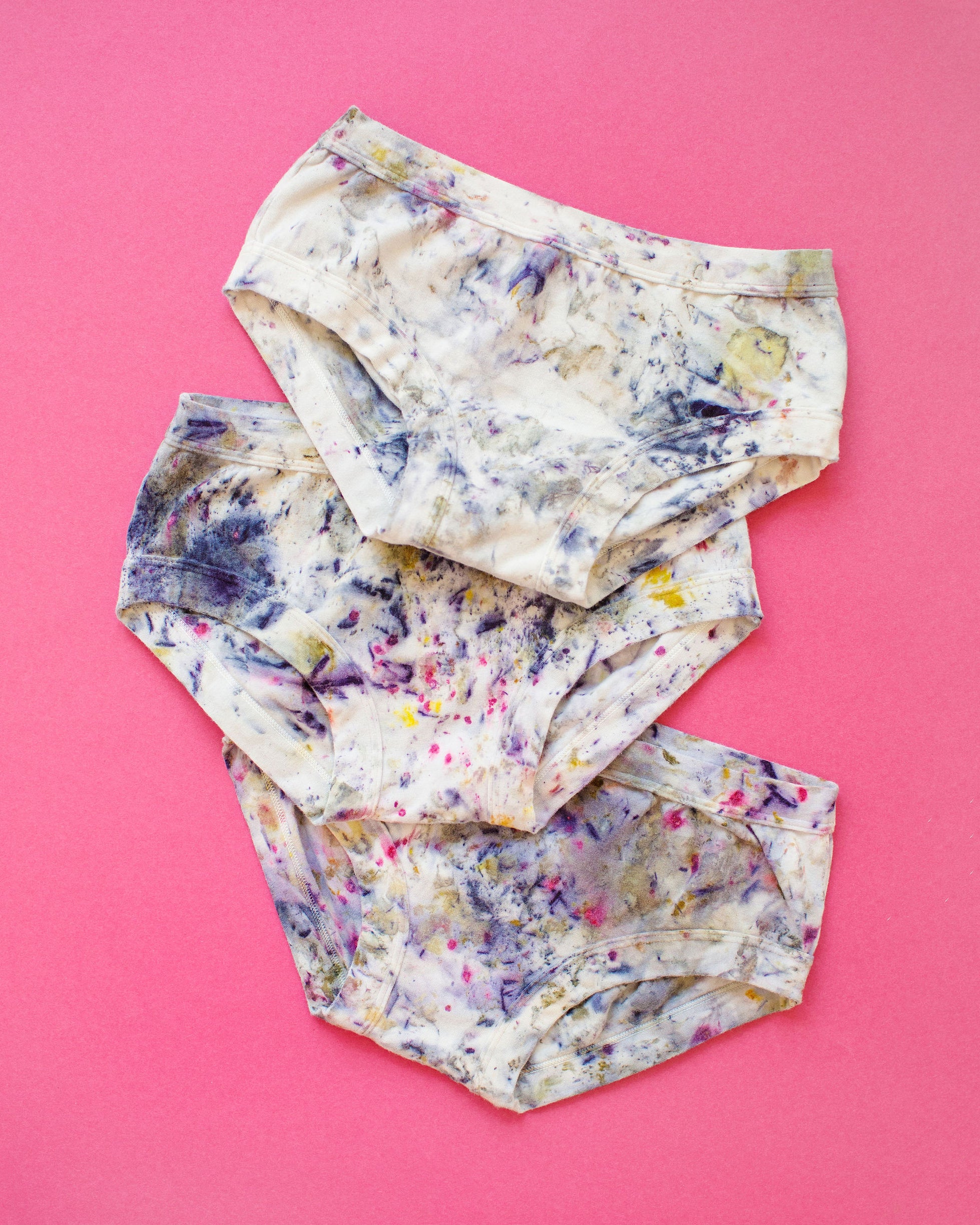 Flat lay of three Thunderpants Hipster style underwear in Cosmic Compost hand dye.