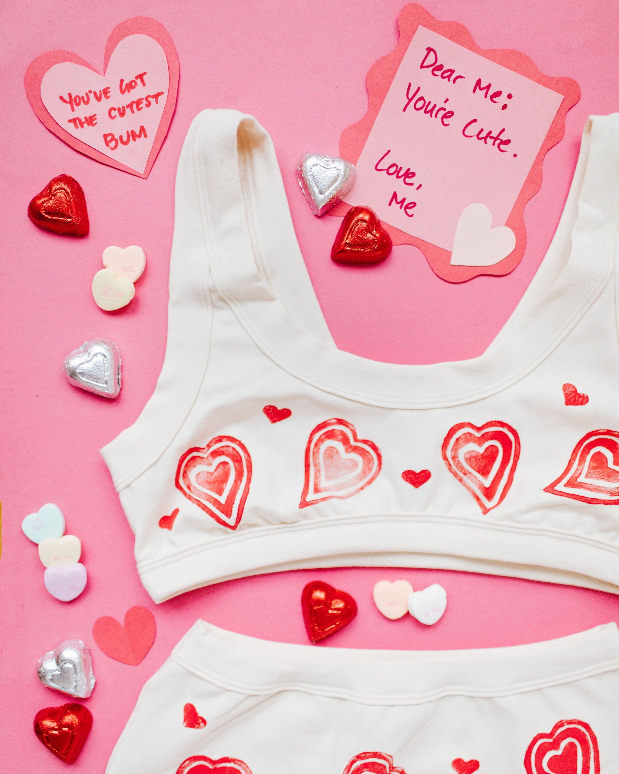Flat lay close up of Thunderpants Bralette  with hand printed red hearts on Vanilla.