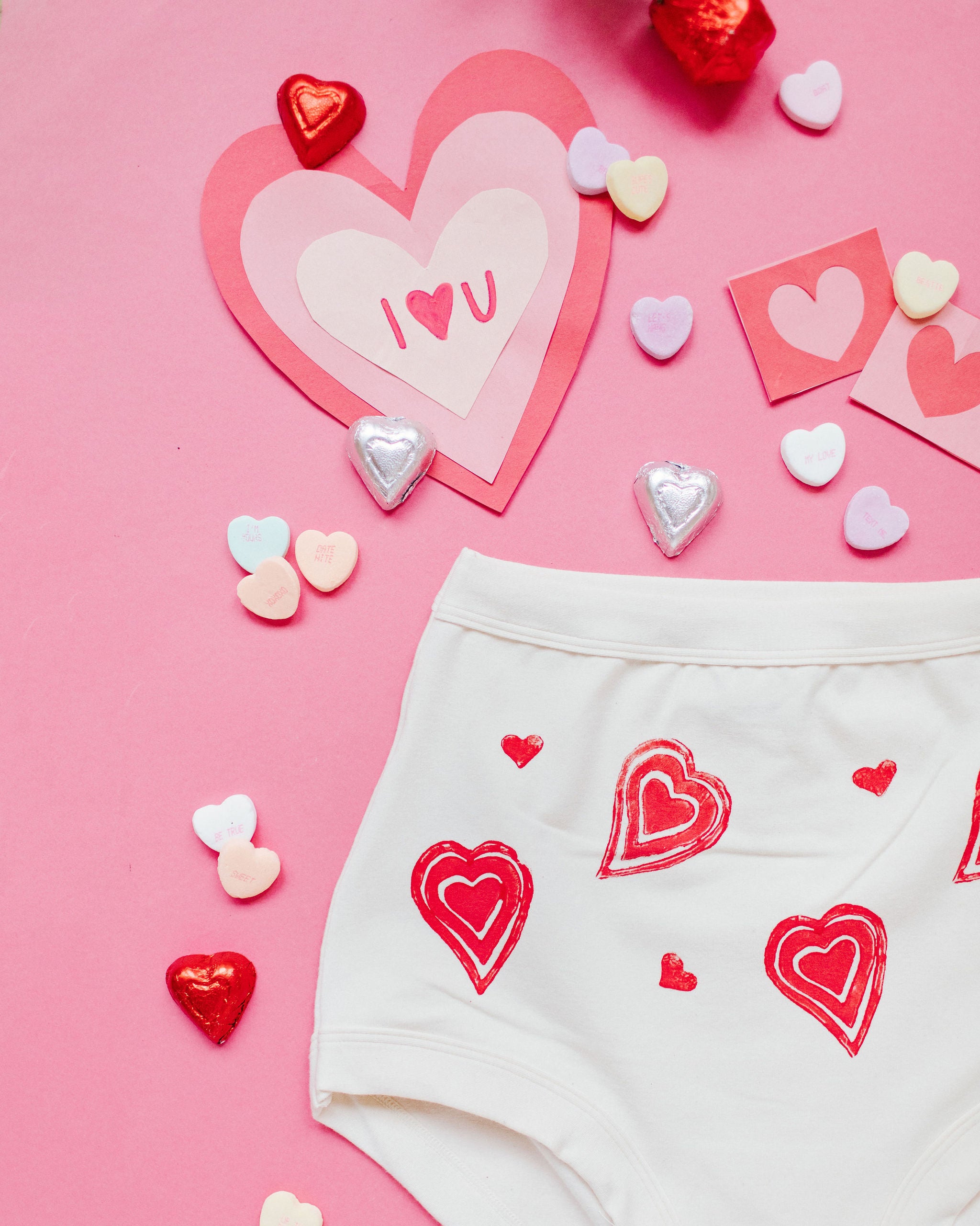 Close up flat lay of Thunderpants Sky Rise style underwear with hand printed red hearts on Vanilla.