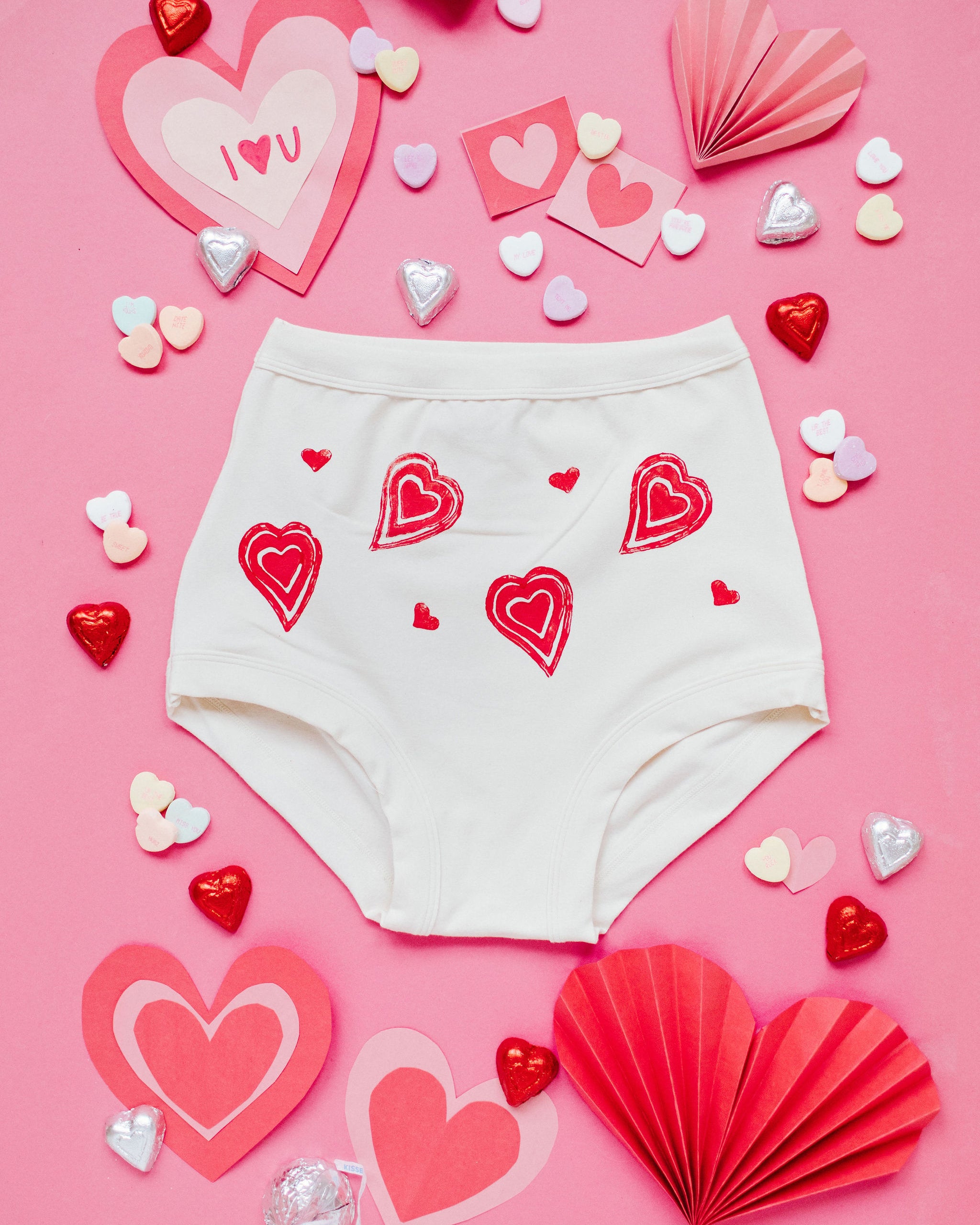 Flat lay of Thunderpants Sky Rise style underwear with hand printed red hearts on Vanilla.