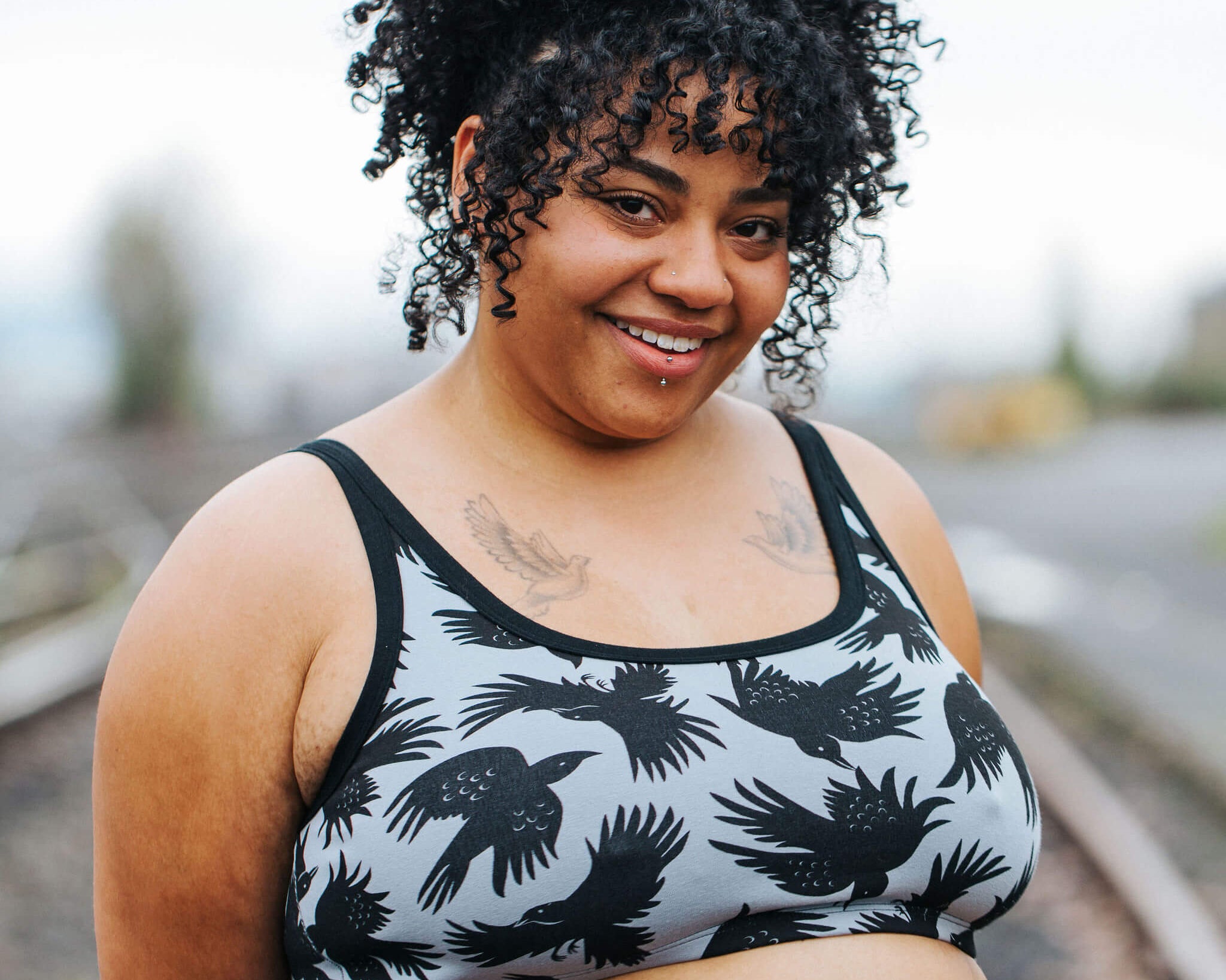 Model wearing Thunderpants Longline Bra in So it Crows - black crows on grey.