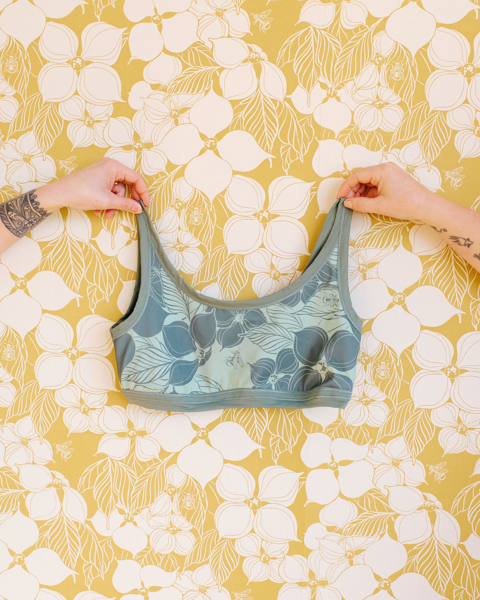 Hands holding Thunderpants Swimwear Top in Dogwood by Lonesome Pictopia.