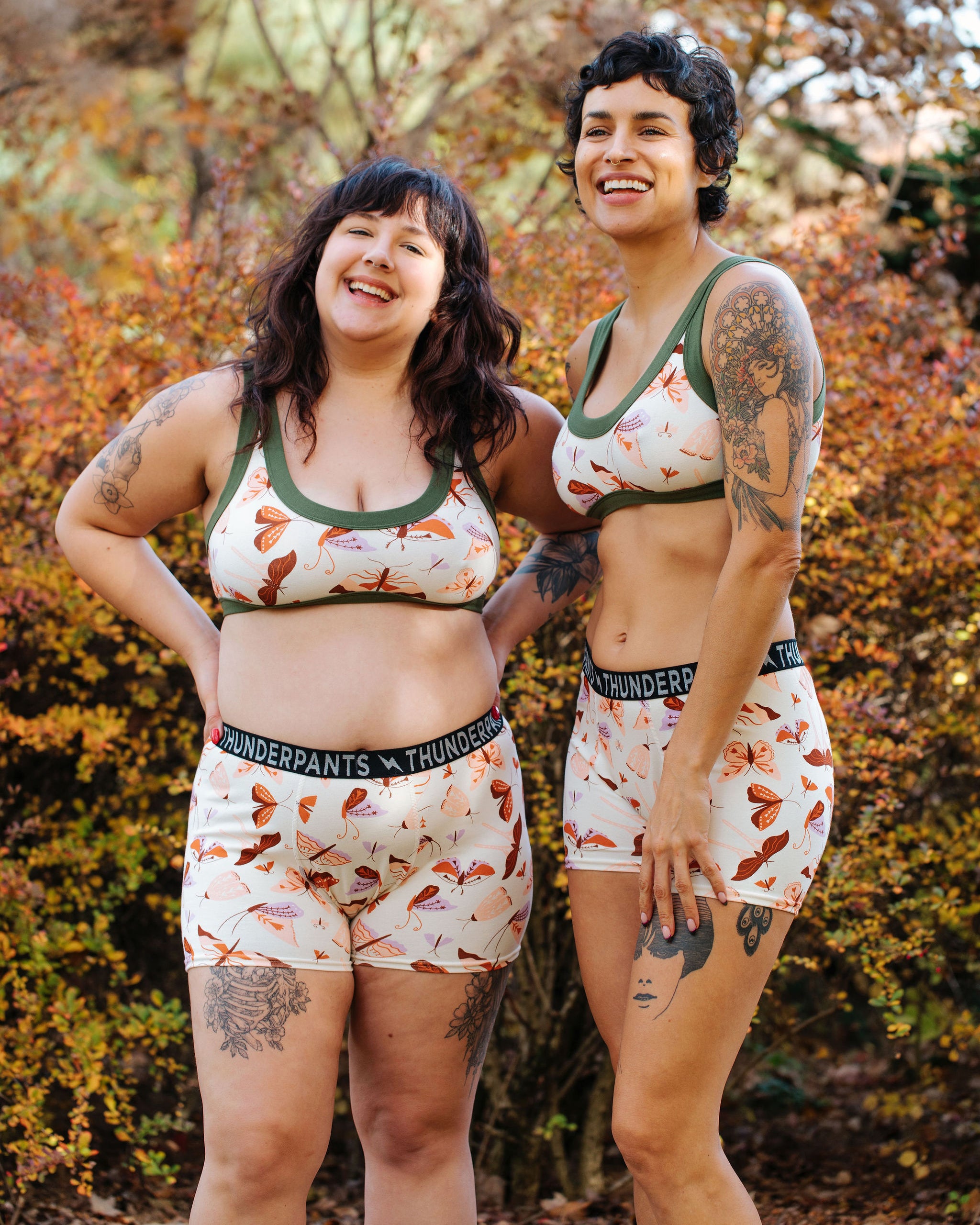 Two models wearing Thunderpants Boxer Brief style underwear and Bralettes n Field Day: a moth print in red, orange, pink, and purple.