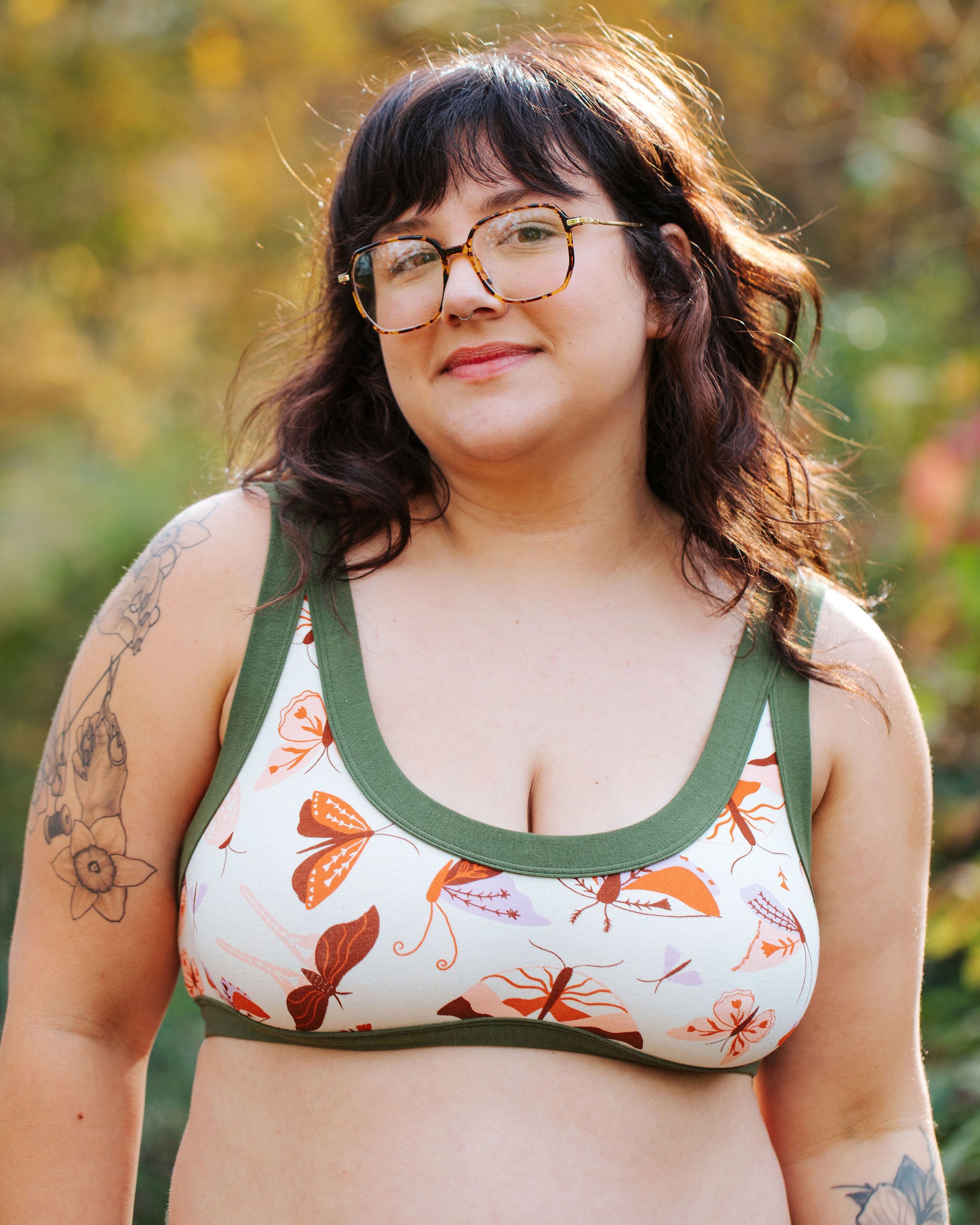 Model wearing Thunderpants a Bralette in Field Study: a moth print in red, orange, pink, and purple bound in green.