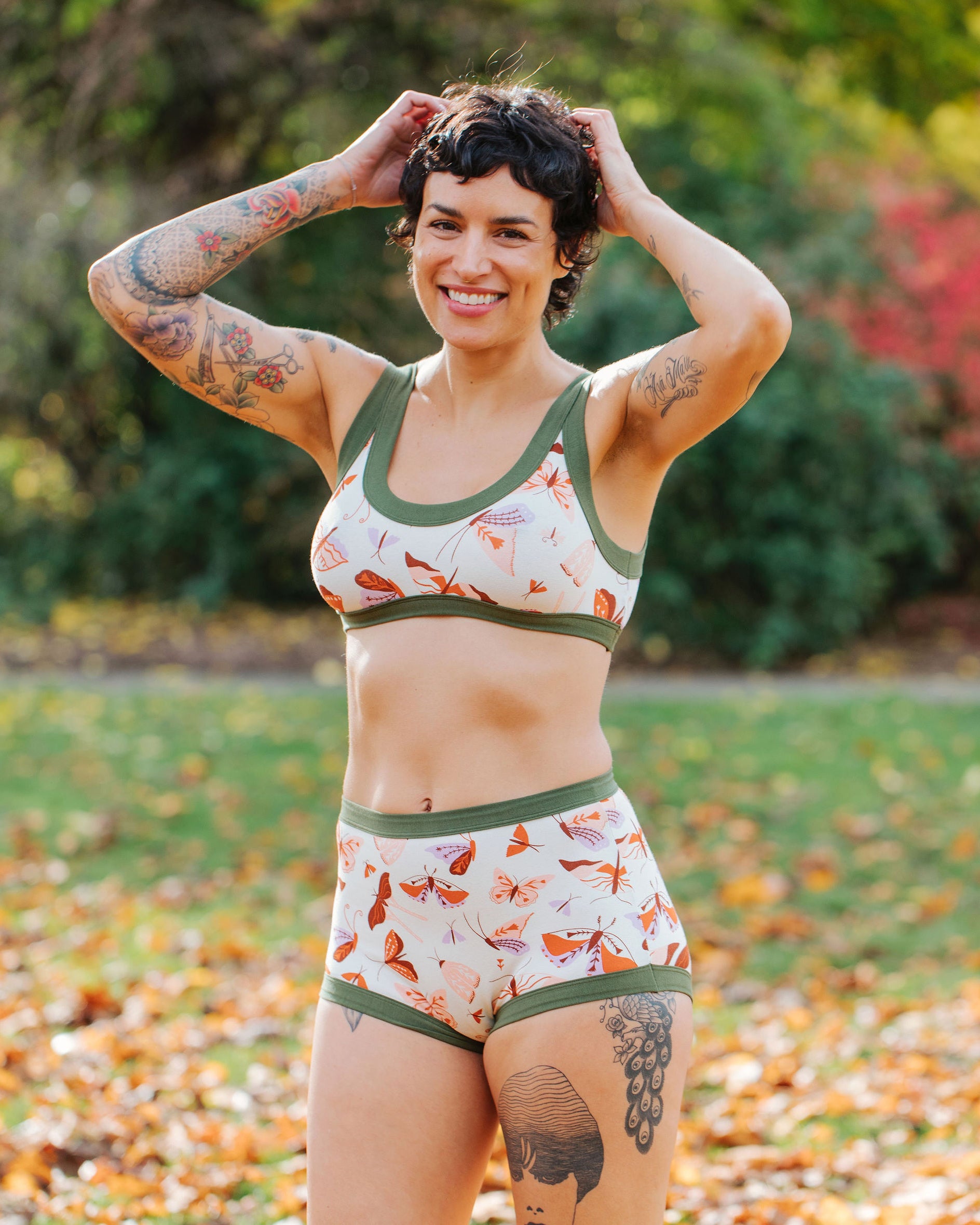 Model wearing Thunderpants Bralette and Sky Rise style underwear in Field Study: a moth print in red, orange, pink, and purple bound in green.