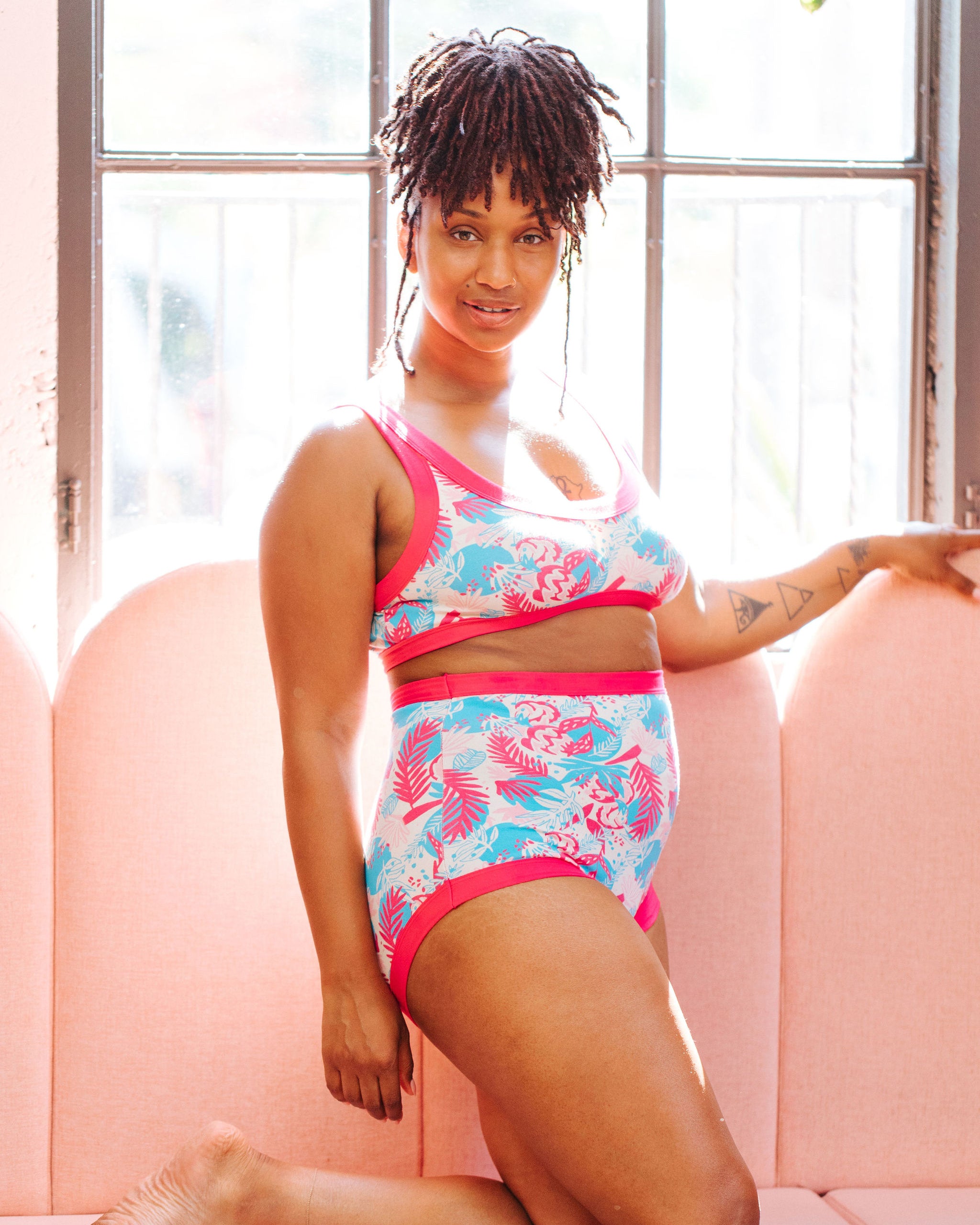 Model wearing a set of Thunderpants Sky Rise style underwear and Bralette in Finding Flamingos - pink and blue Miami-inspired print.