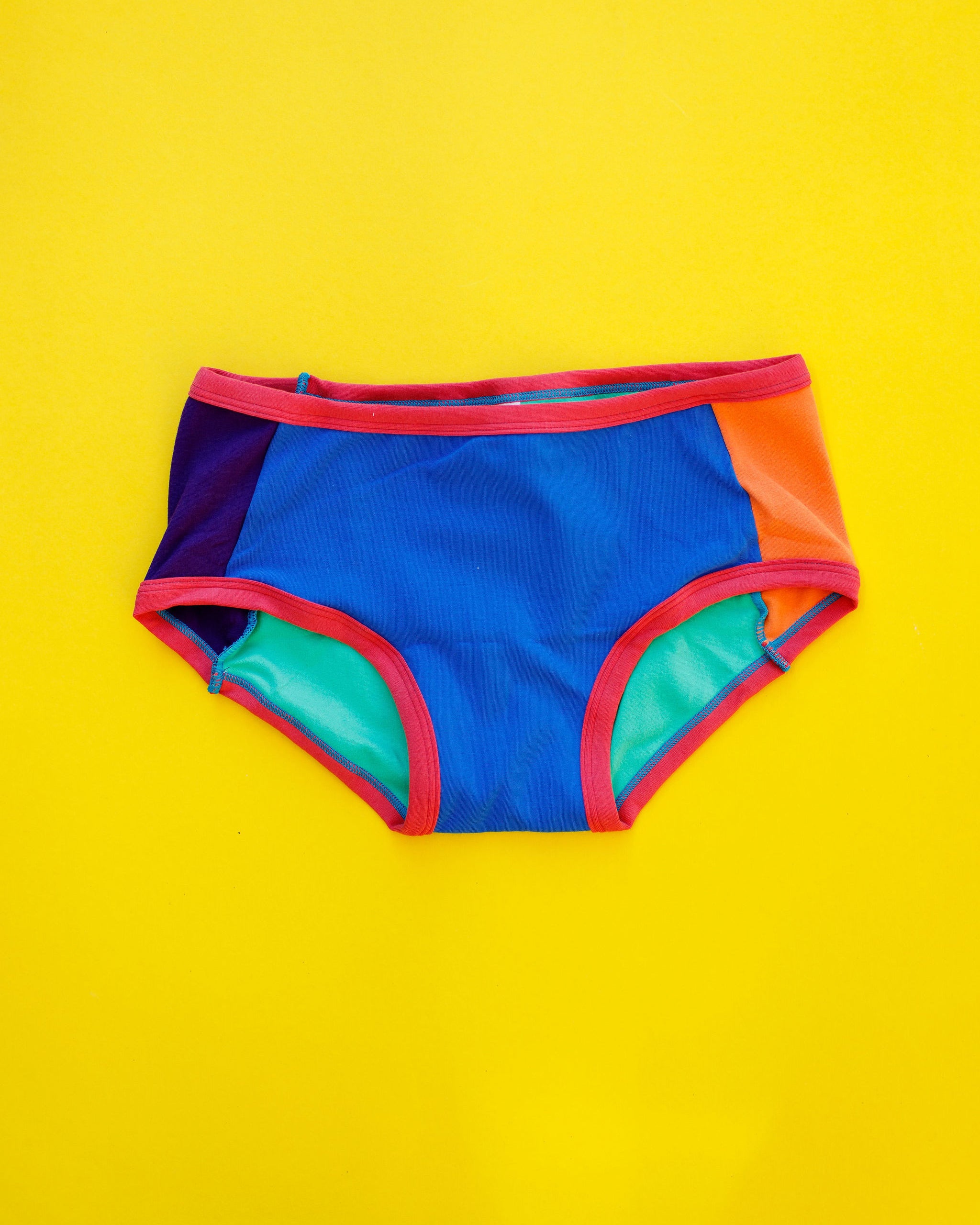 Flat lay of Thunderpants Panel Pants Hipster style underwear in Color Block Scraps - various solid colors.