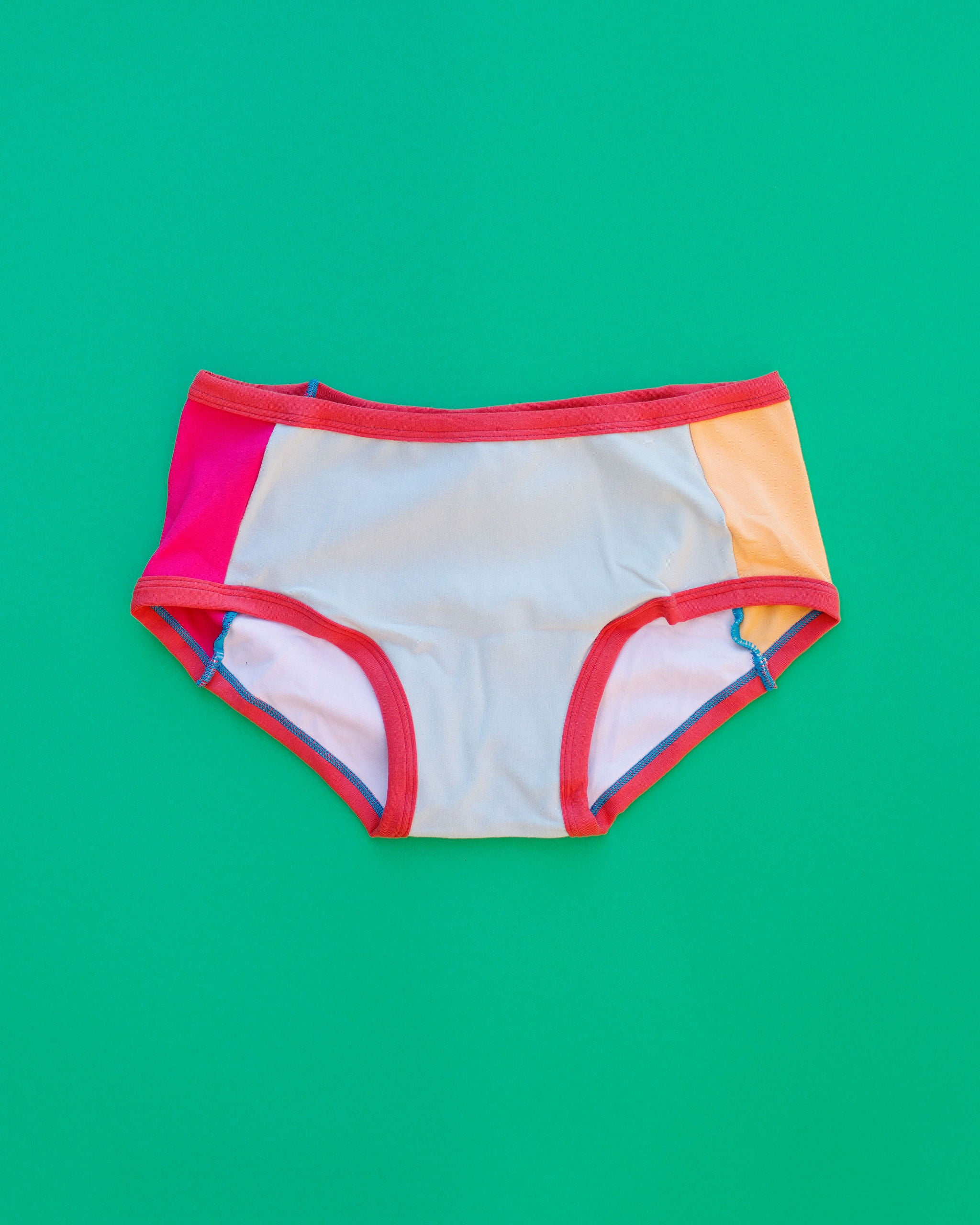Flat lay of Thunderpants Panel Pants Hipster style underwear in Color Block Scraps - various solid colors.