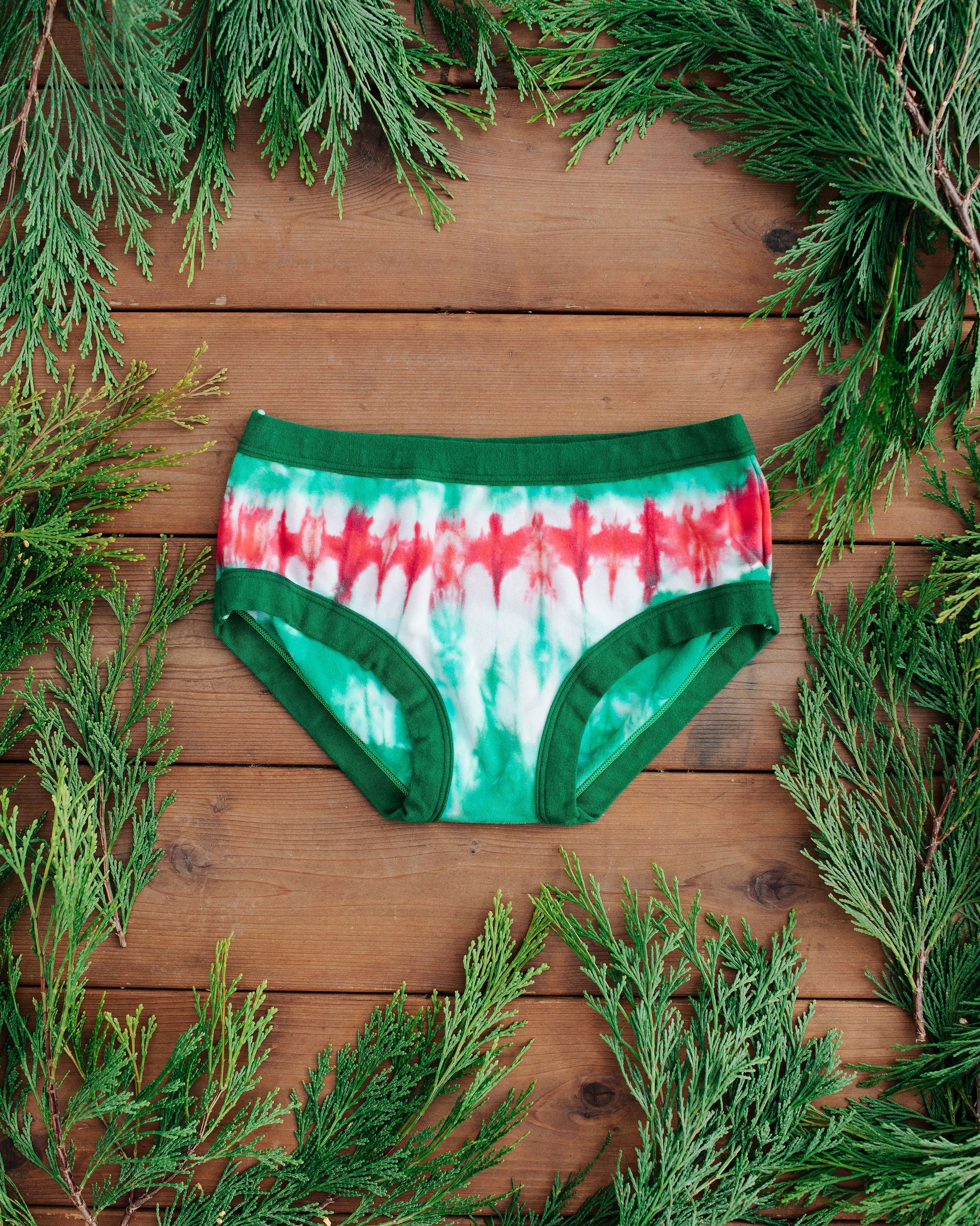 Flat lay of Thunderpants Hipster style underwear in Holiday Dye - red and green tie dye with green binding. 