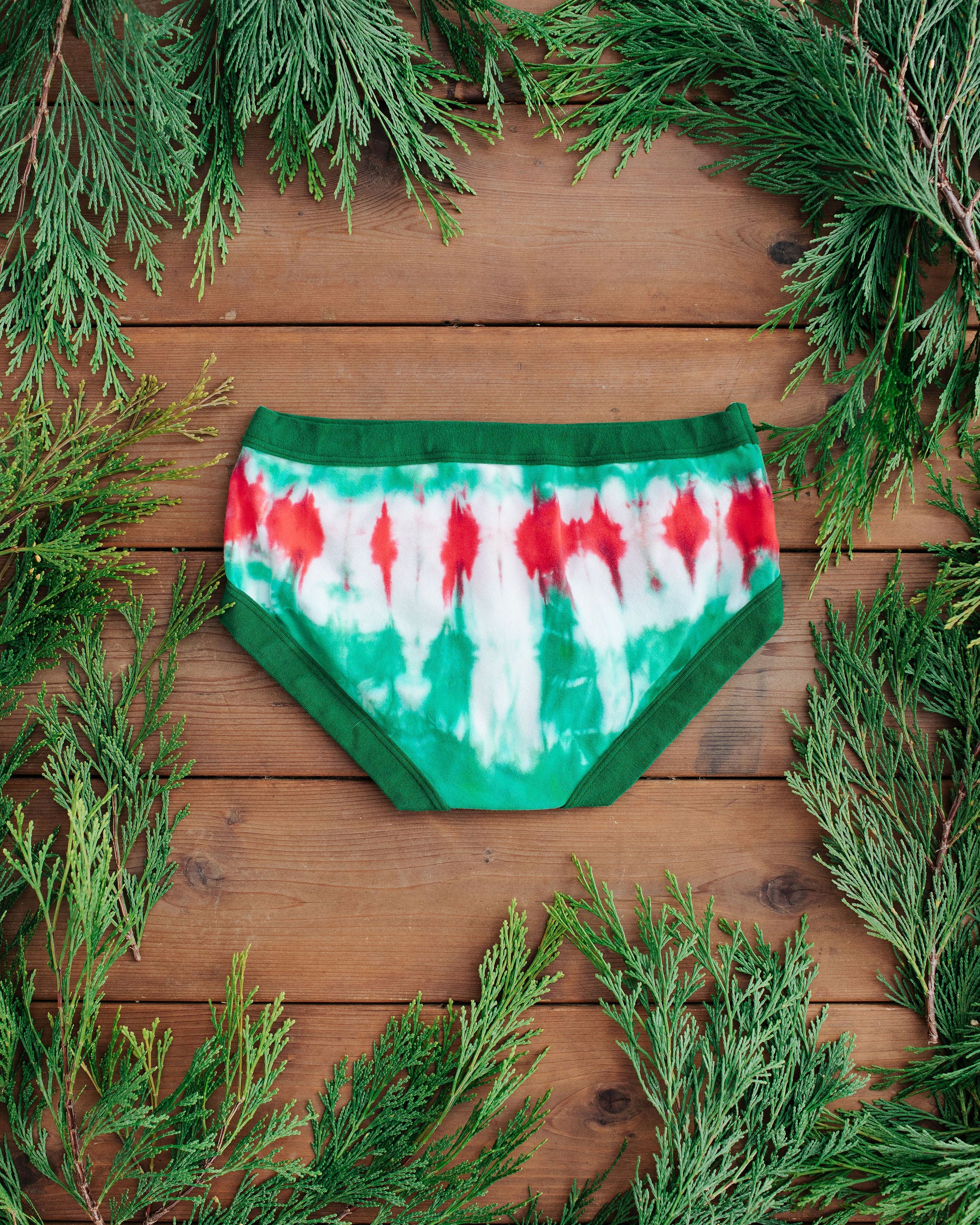 Flat lay of Thunderpants Hipster style underwear in Holiday Dye - red and green tie dye with green binding. 