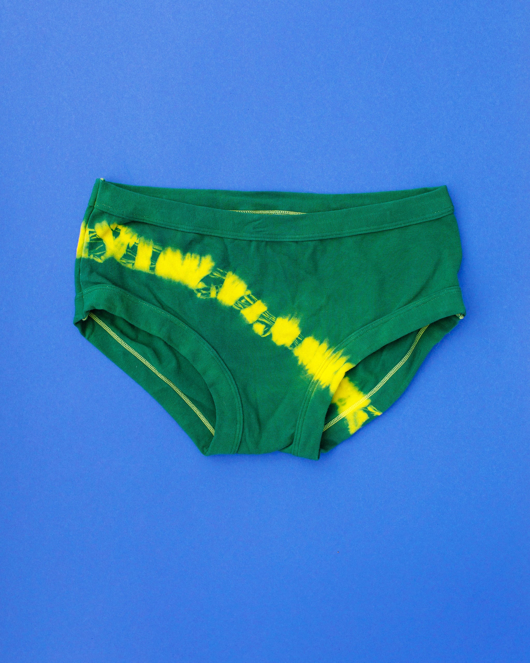 Flat lay of Thunderpants Hipster style underwear in Lightning Bolt hand dye - blue/green with yellow stripe.