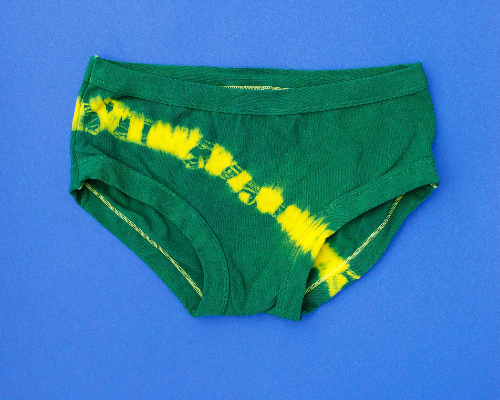 Flat lay of Thunderpants Hipster style underwear in Lightning Bolt hand dye - blue/green with yellow stripe.