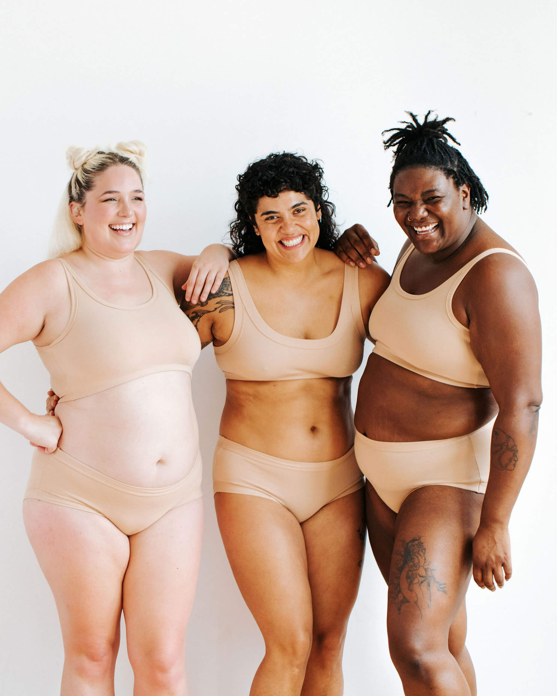 Three models wearing Thunderpants Hipster styler underwear and Bras in Pine Nut - lighter tan color.