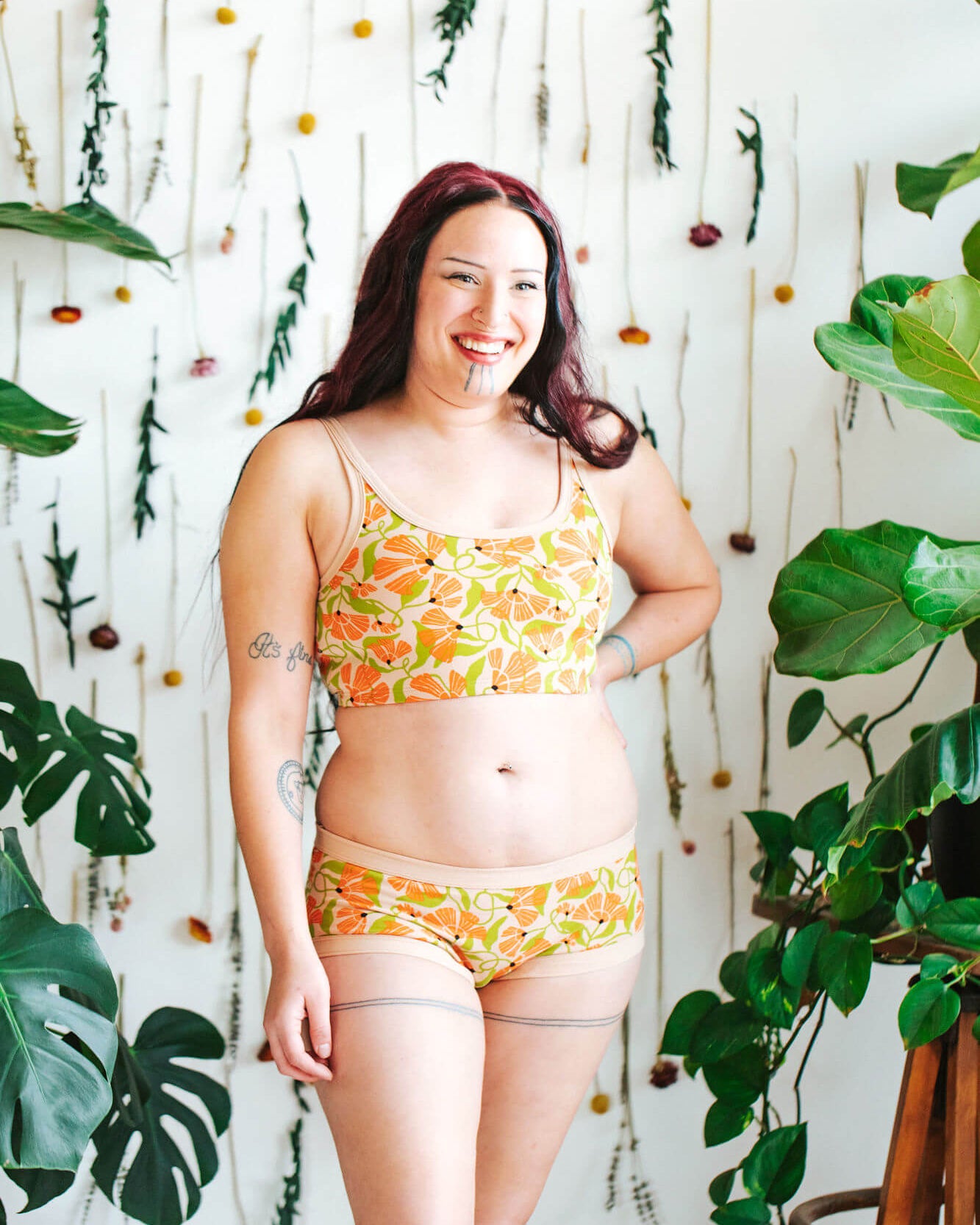 Model wearing a set of Thunderpants Hipster style underwear and Longline Bra in Secret Garden - orange flowers and green leaves.