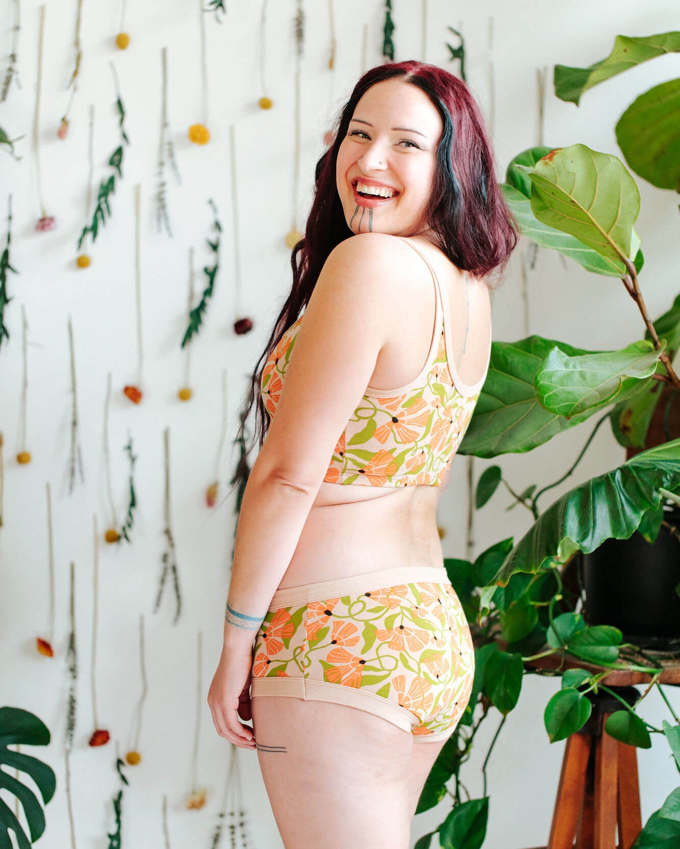 Model wearing a set of Thunderpants Hipster style underwear and Longline Bra in Secret Garden - orange flowers and green leaves.