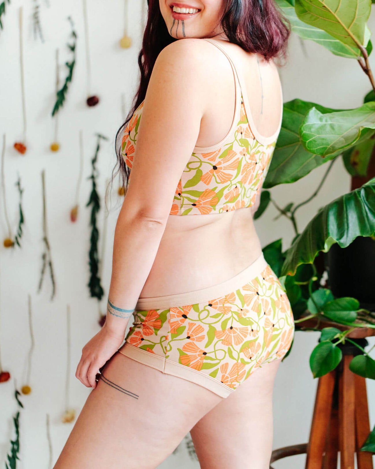 Model wearing a set of Thunderpants Hipster style underwear and Longline Bra in Secret Garden - orange flowers and green leaves.