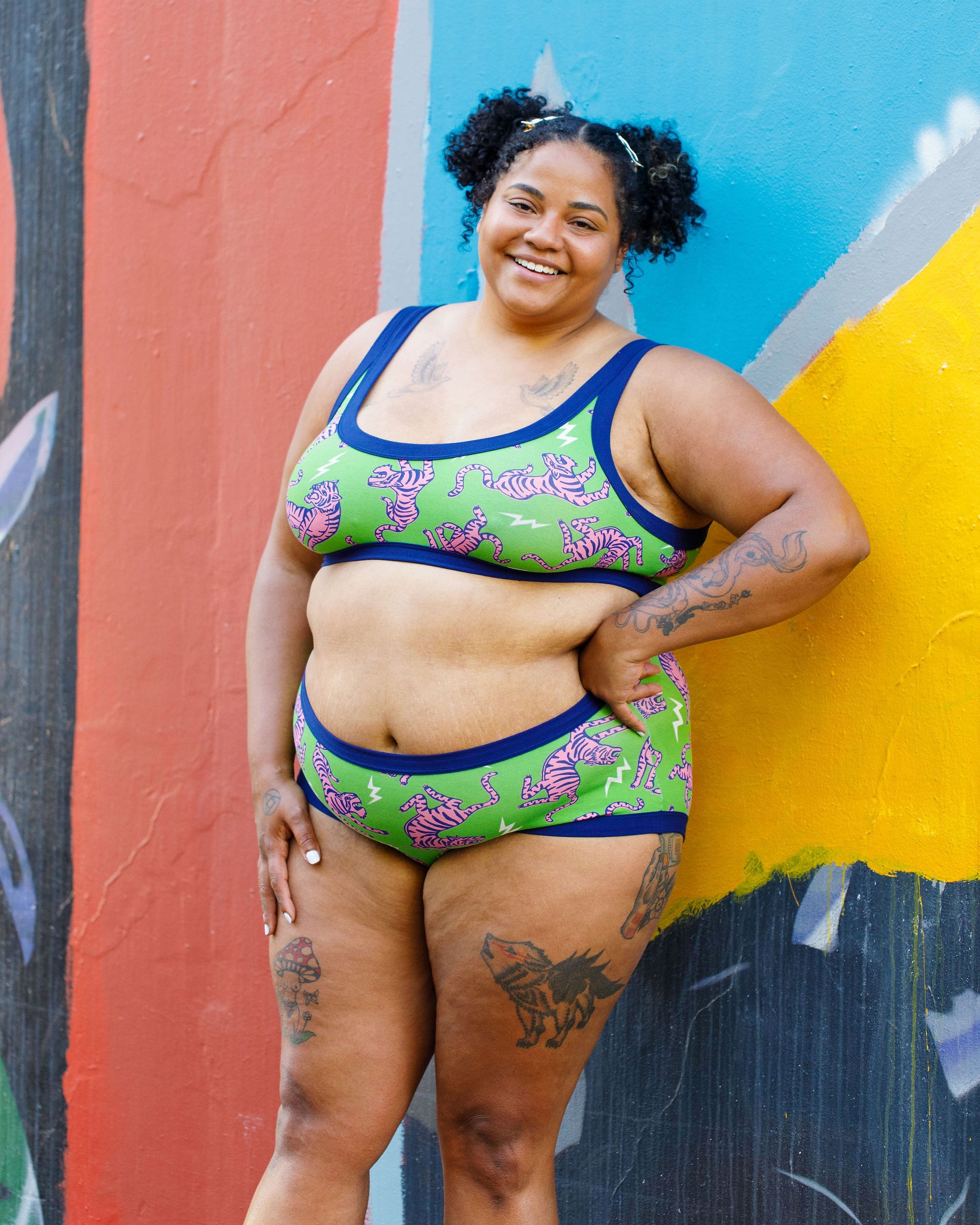Model wearing Thunderpants organic cotton Hipster style underwear and Bralette in Electric Tiger - green with pink and blue tigers and white lightning bolts.