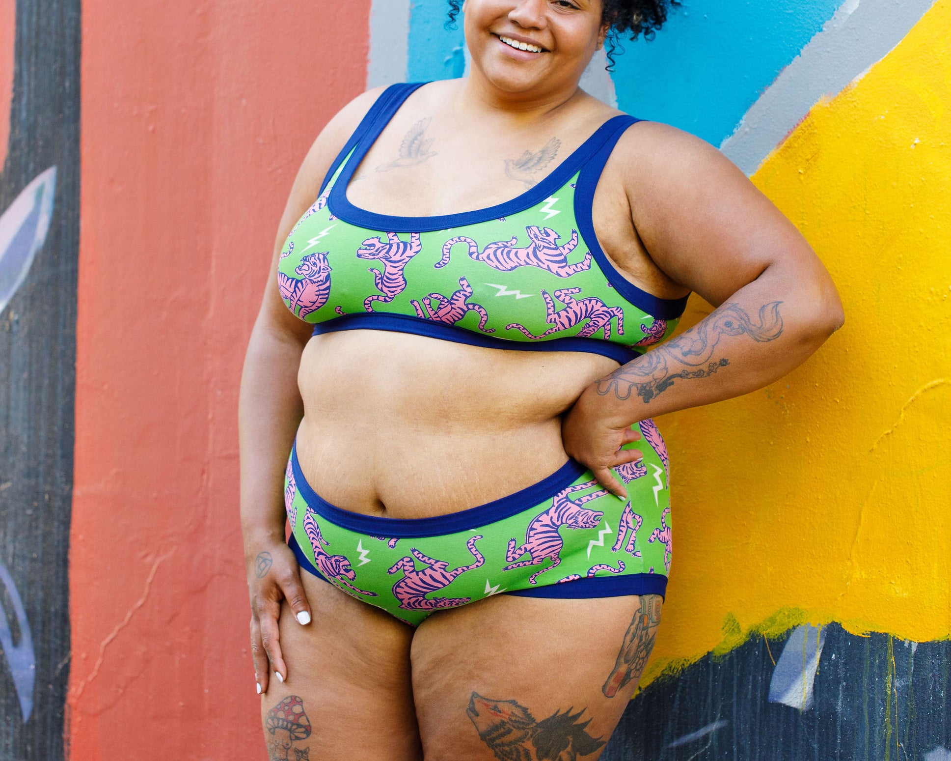 Model wearing Thunderpants organic cotton Hipster style underwear and Bralette in Electric Tiger - green with pink and blue tigers and white lightning bolts.