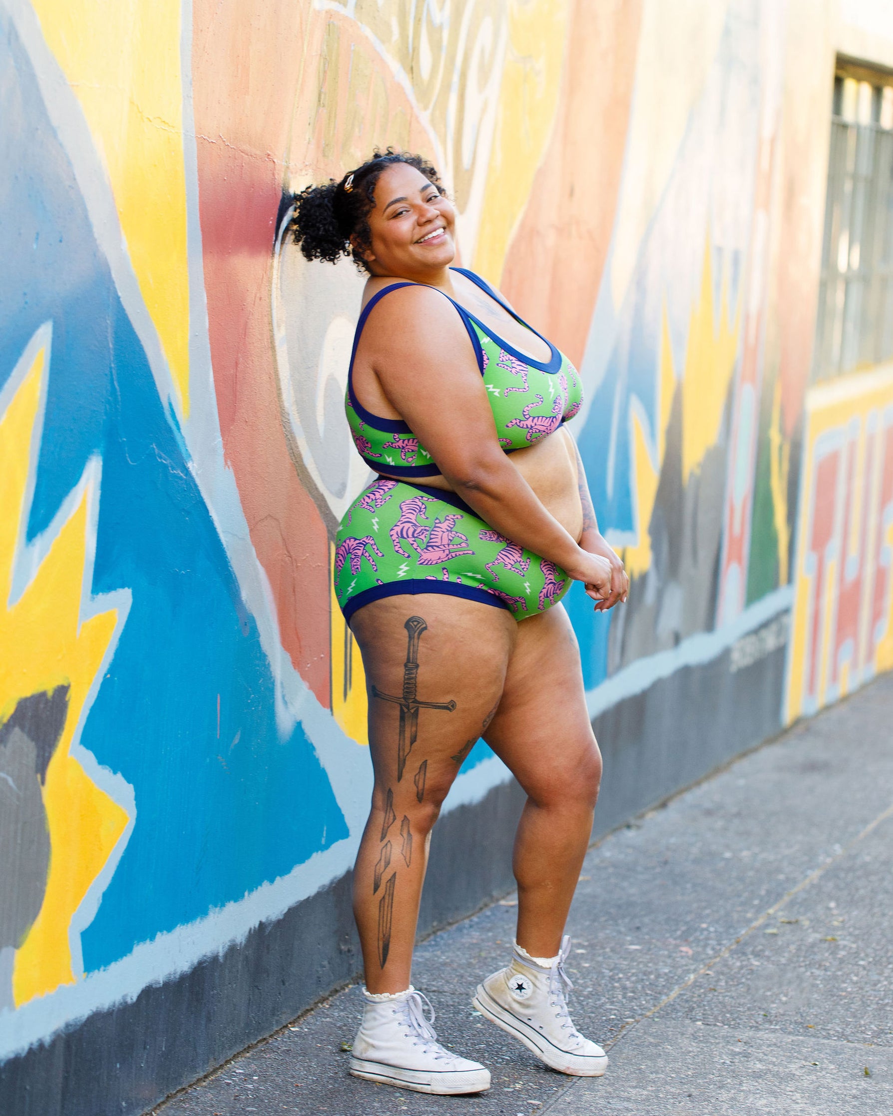 Model wearing Thunderpants organic cotton Hipster style underwear and Bralette in Electric Tiger - green with pink and blue tigers and white lightning bolts.