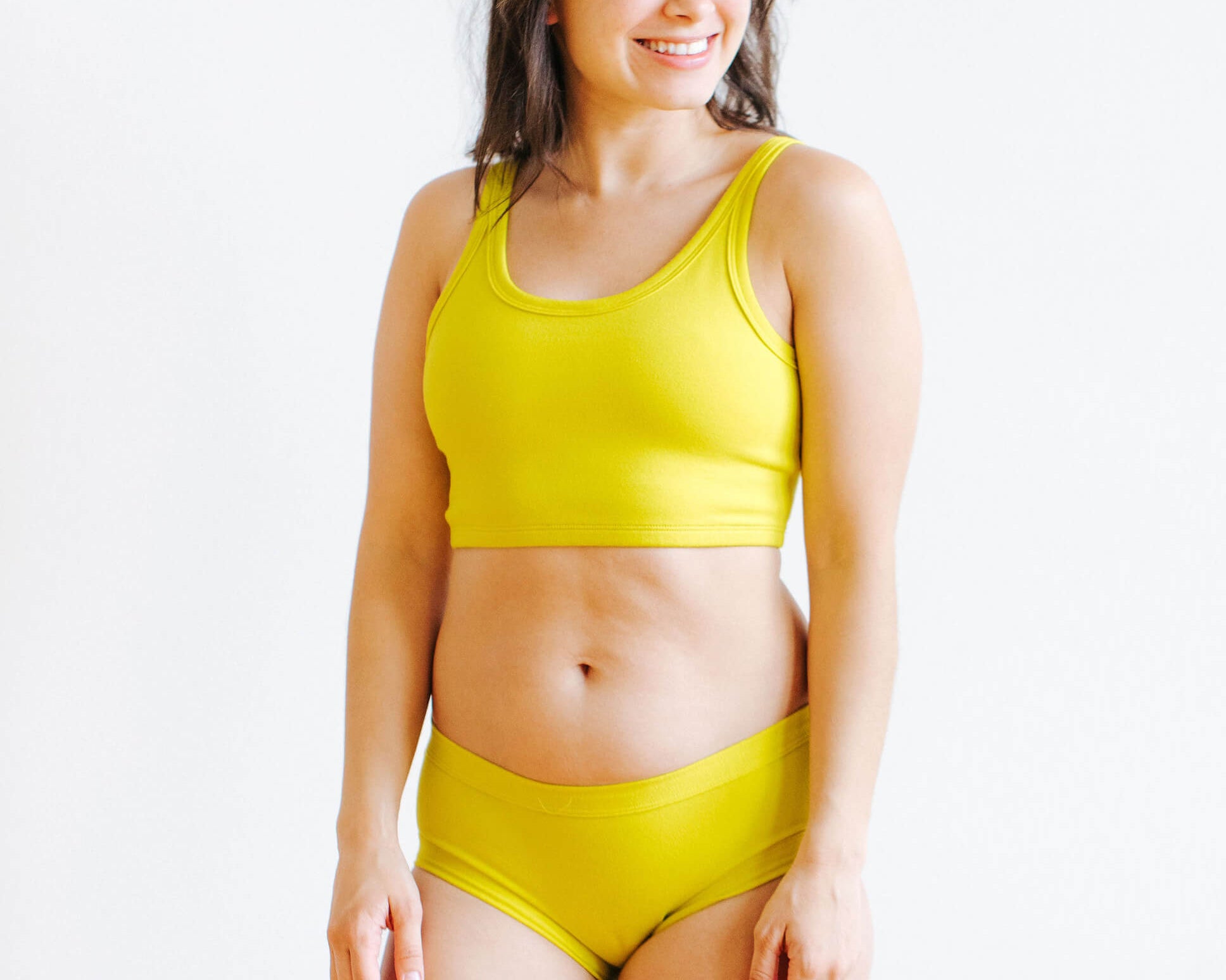 Model wearing Thunderpants Hipster style underwear and Longline Bra in Star Fruit color - a chartreuse yellow.
