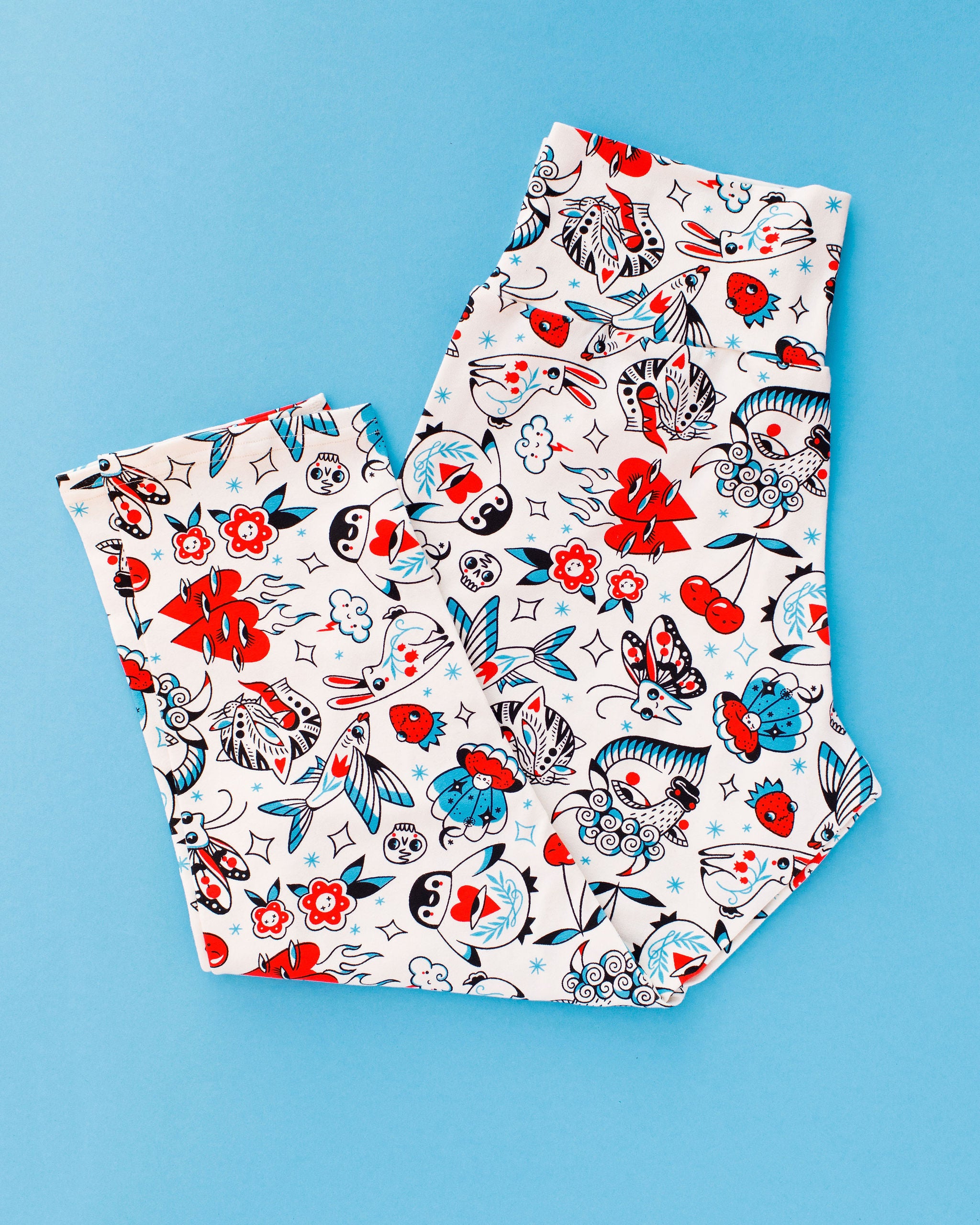 Flat lay of Thunderpants 3/4 Length Leggings in Inked Up print - tattoo inspired drawings in black, red, and blue colors.