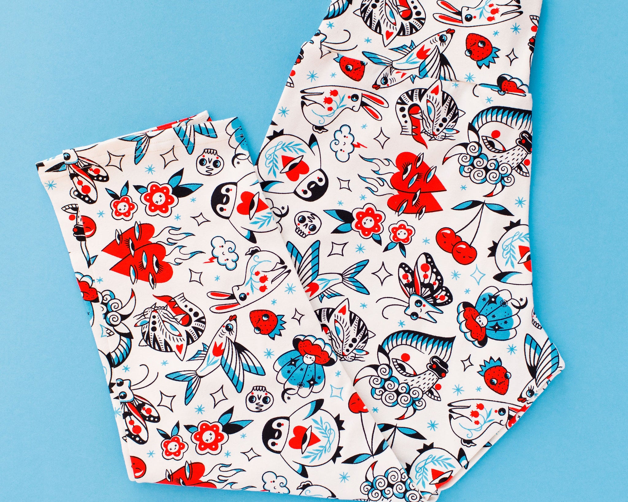 Flat lay of Thunderpants 3/4 Length Leggings in Inked Up print - tattoo inspired drawings in black, red, and blue colors.