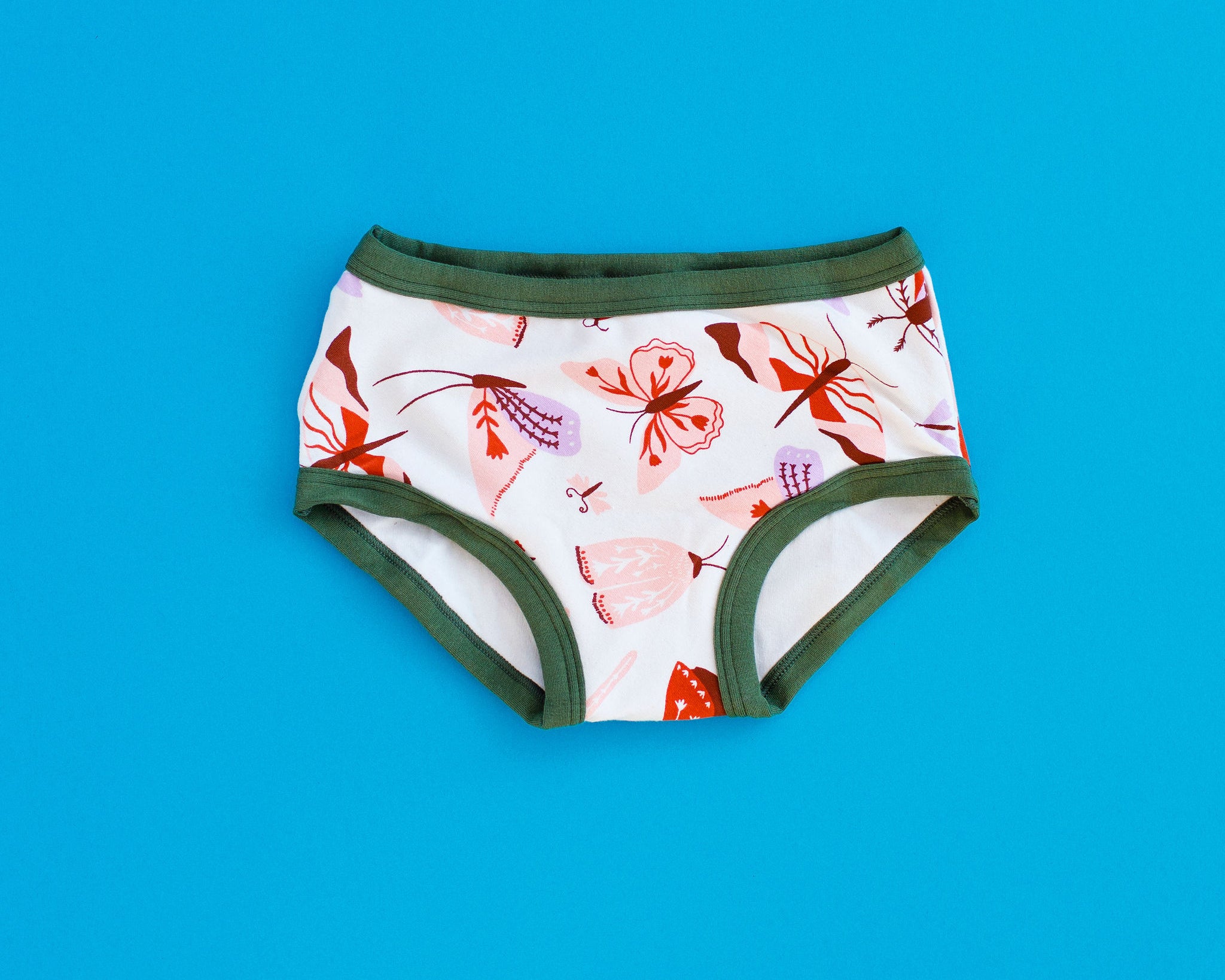 Flat lay of Thunderpants Kids style underwear in Field Study - pink, brown, and orange moths.