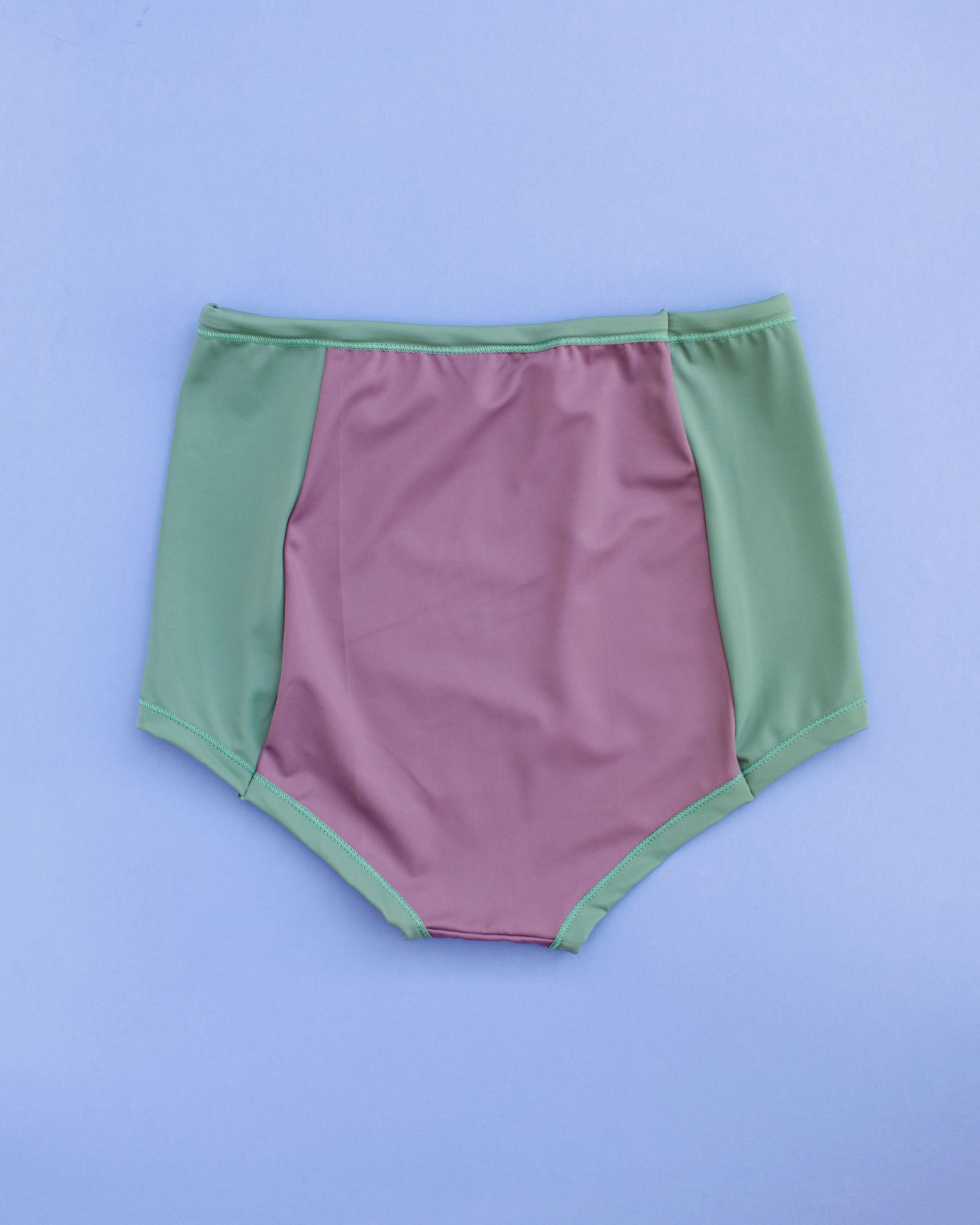 Flat lay of Swimwear Sky Rise Panel Bottom in lavender and lichen green.