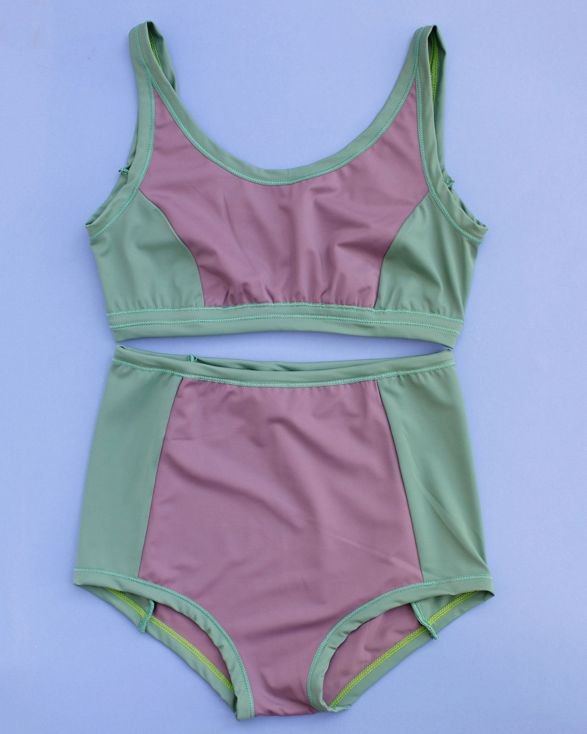Flat lay of Swimwear Sky Rise Panel Bottom and Swim Panel Top in lavender and lichen green.