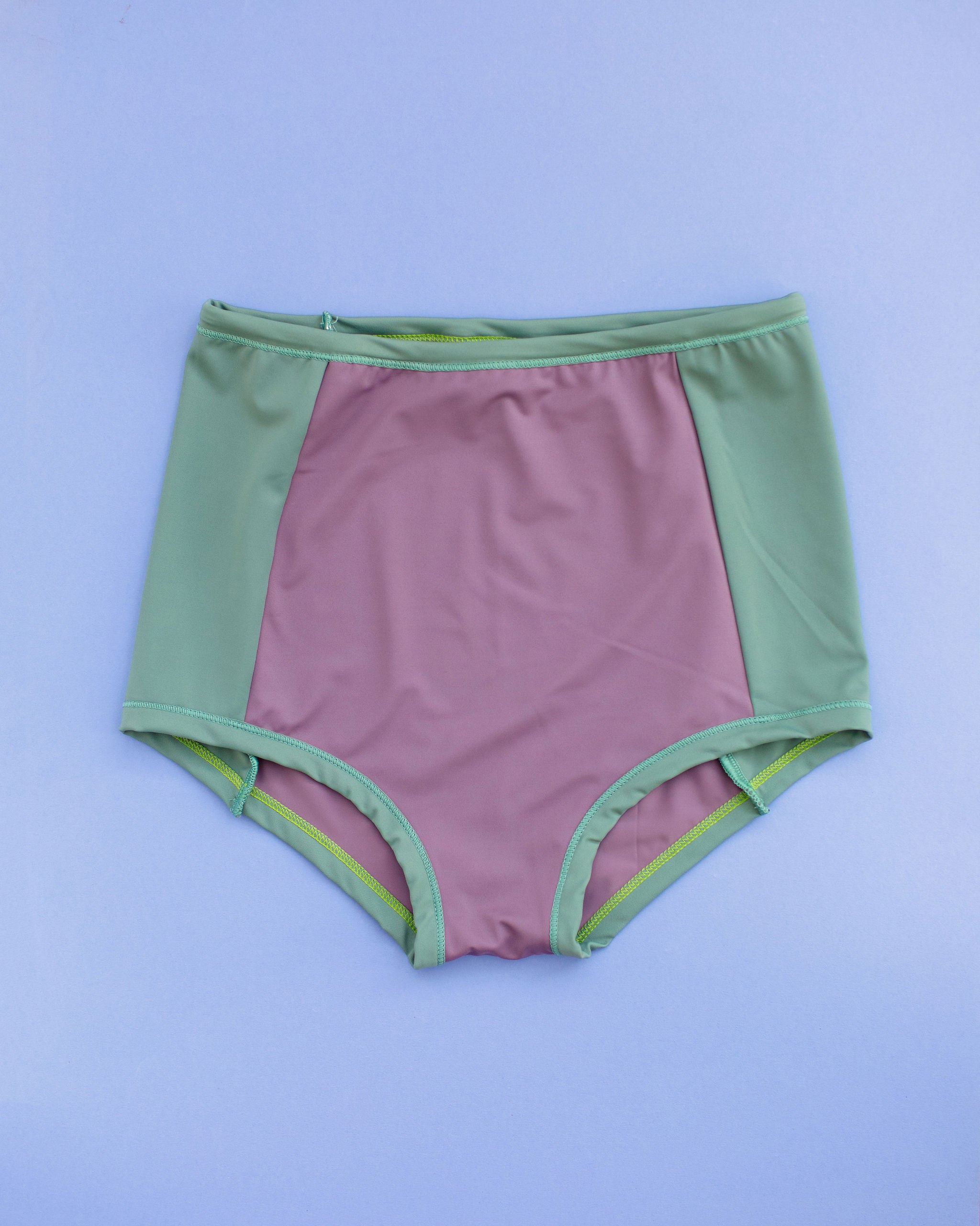 Flat lay of Swimwear Sky Rise Panel Bottom in lavender and lichen green.