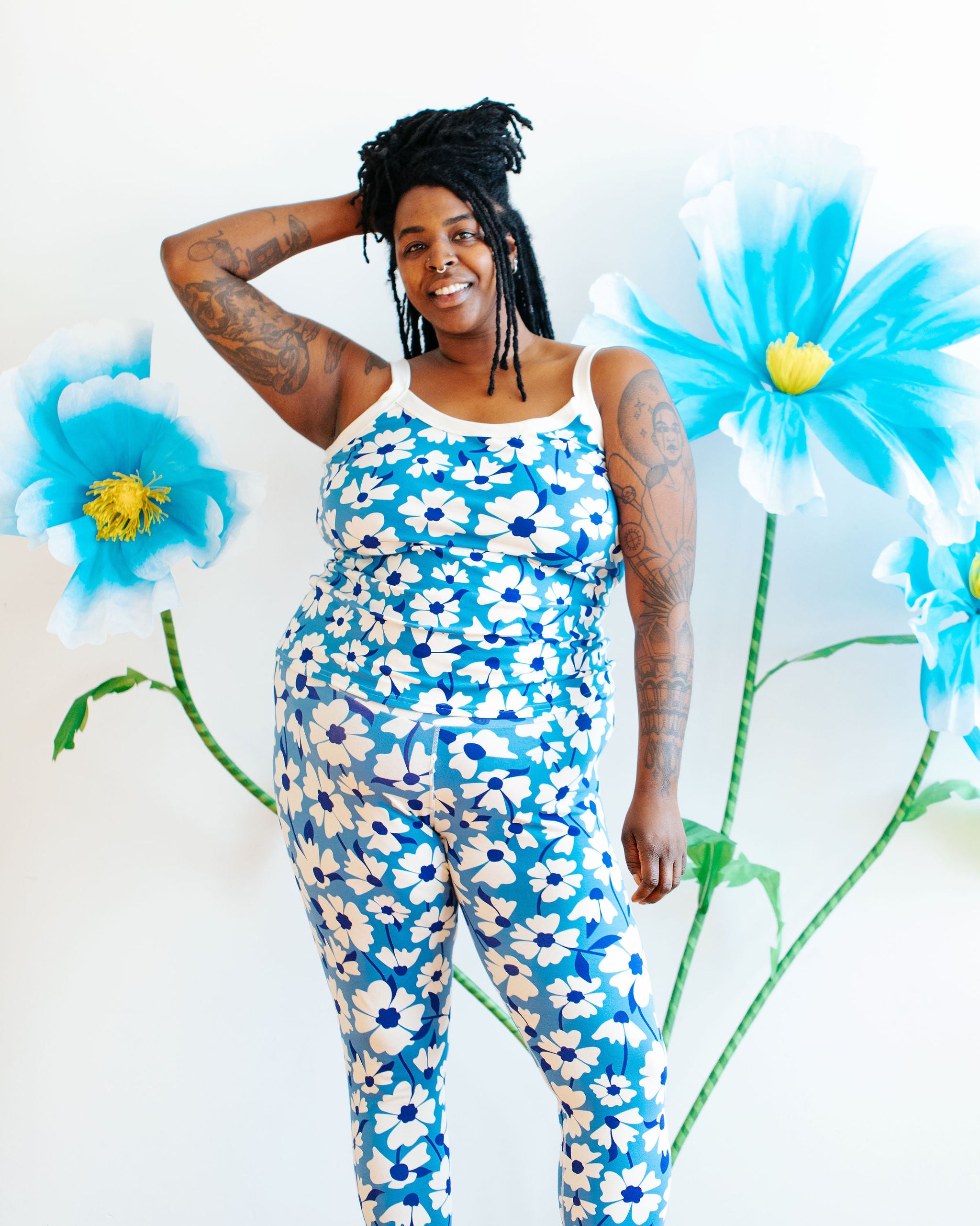 Model wearing Thunderpants Ankle Leggings and Camisole in Moody Blooms - white and blue flowers with blue background.