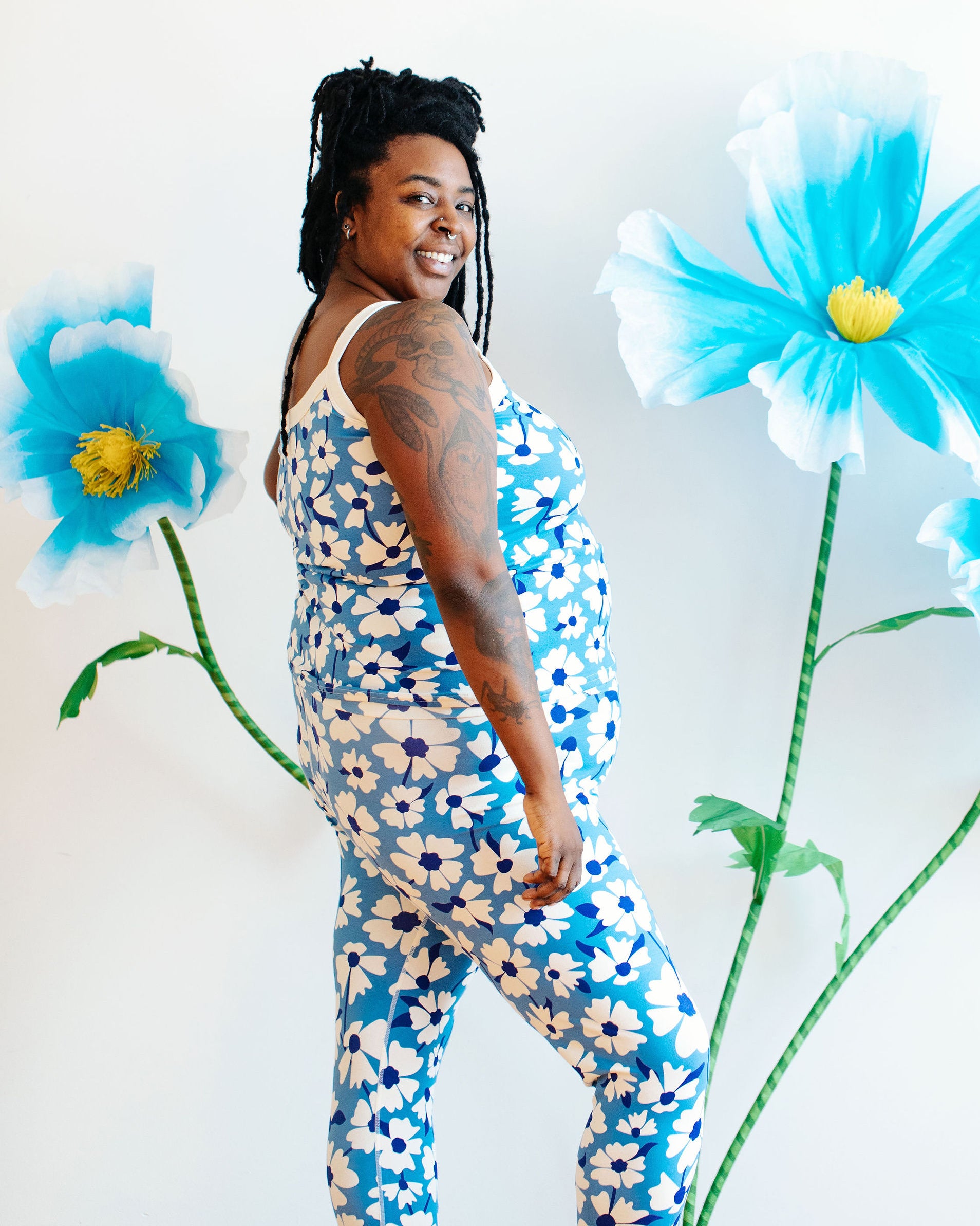 Model wearing Thunderpants Ankle Leggings and Camisole in Moody Blooms - white and blue flowers with blue background.