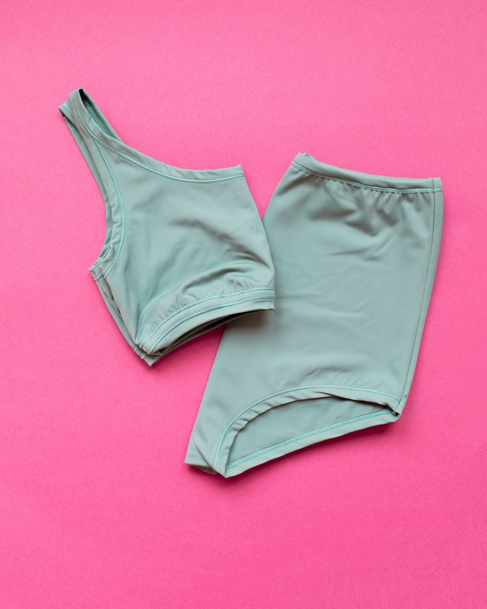 Flat lay of Swimwear Sky Rise Bottoms and Top set in Lichen Green.
