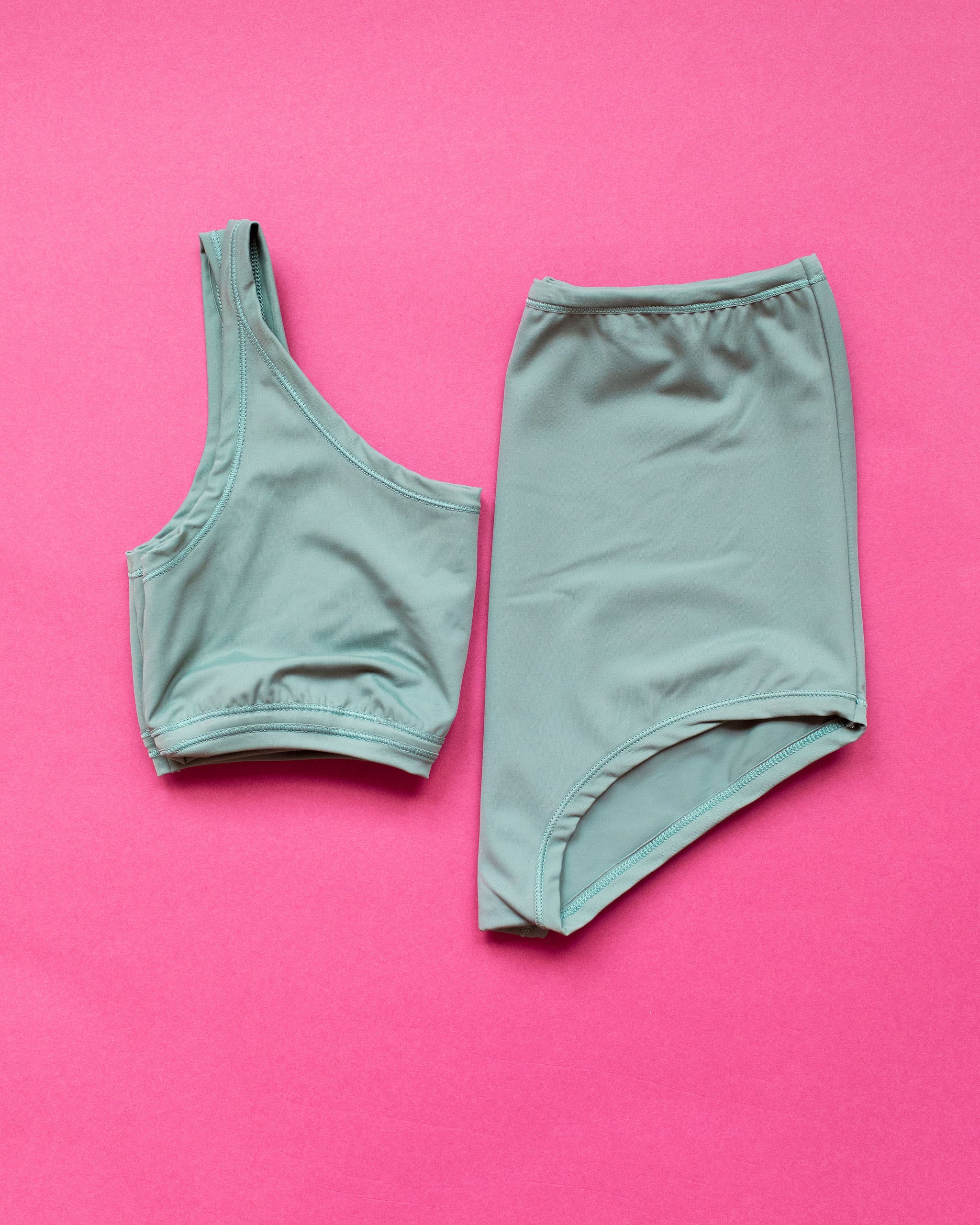 Flat lay of Swimwear Top and Sky Rise Bottoms in Lichen Green.