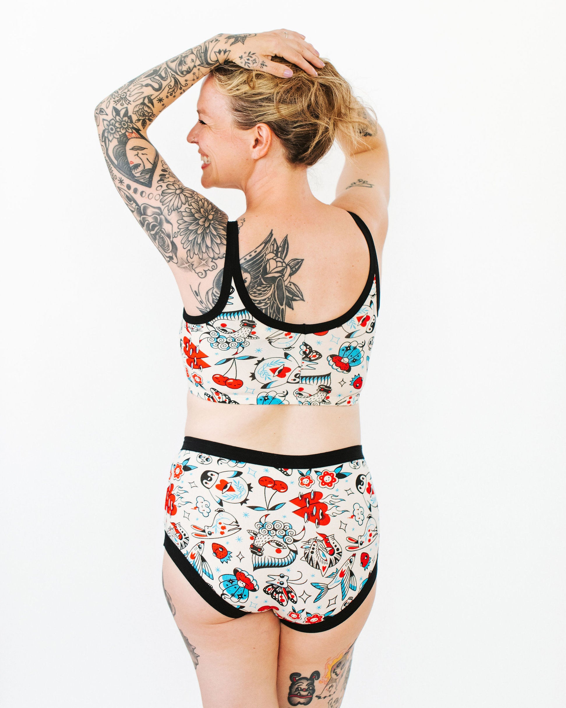 Model wearing Thunderpants Longline Bra and Original style underwear in Inked Up - a tattoo pattern with black, red, and blue. 