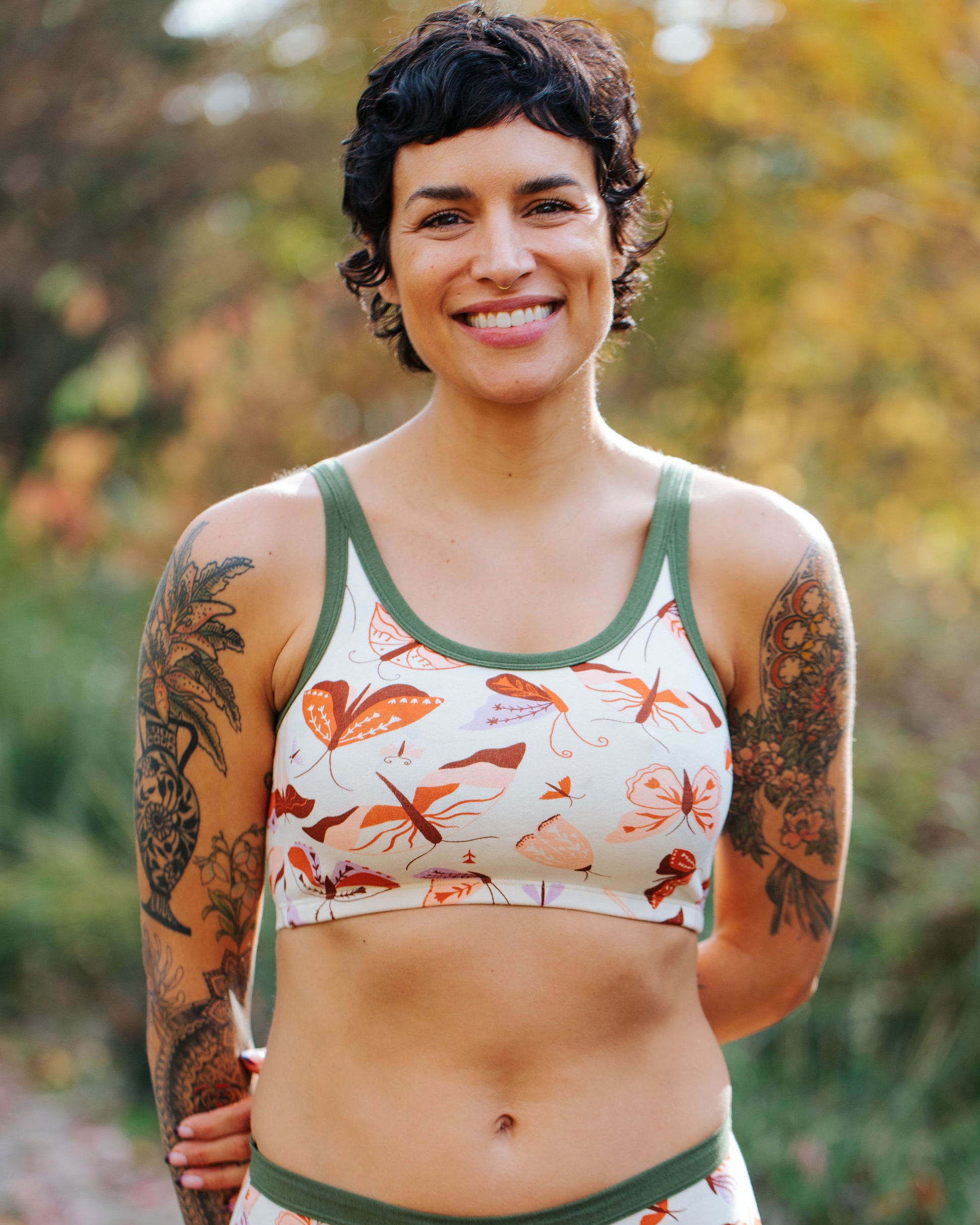 Model wearing Thunderpants Longline Bra in Field Study: a moth print in red, orange, pink, and purple bound in green.