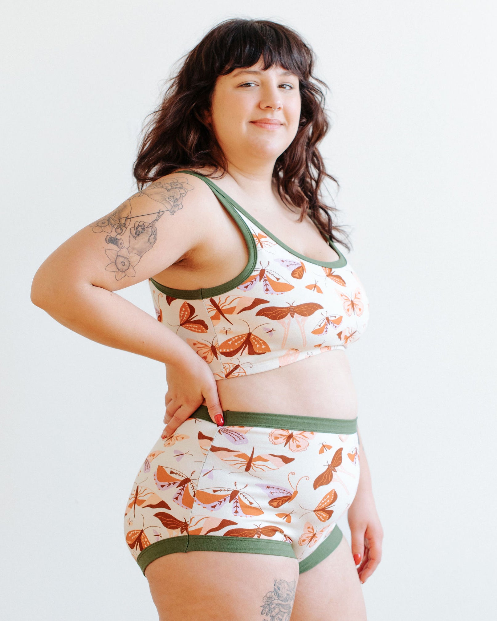 Model wearing Thunderpants Longline Bra and Sky Rise style underwear in Field Study: a moth print in red, orange, pink, and purple bound in green.