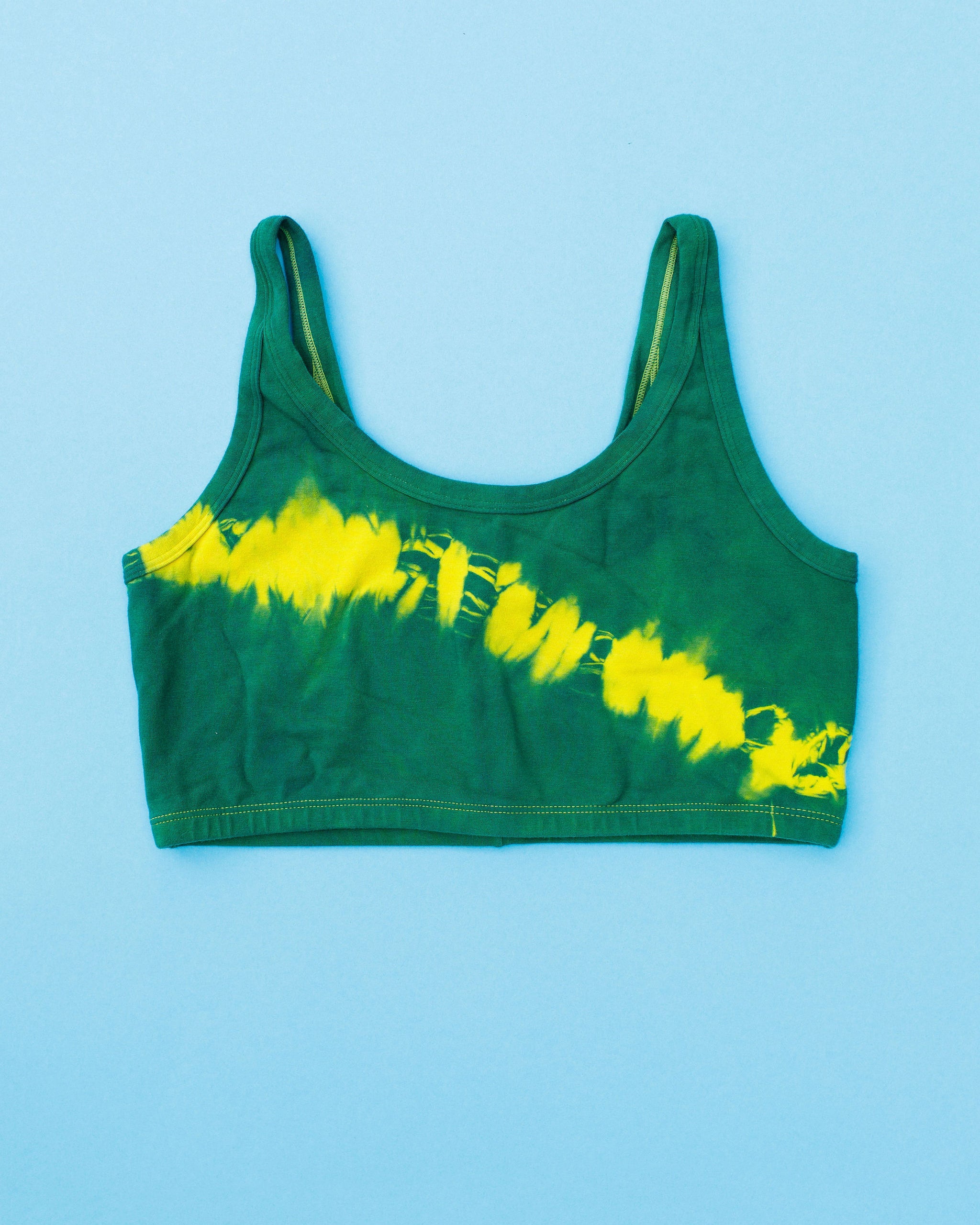 Flat lay of Thunderpants Longline Bra in Lightning Bolt Hand Dye - blue/green with yellow stripe.